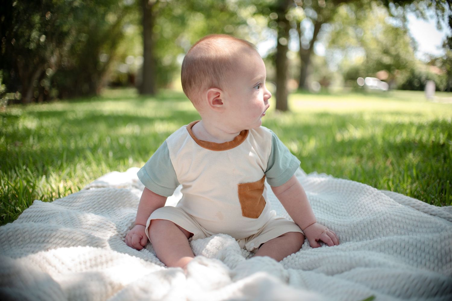 Baby sitting on blanket during outdoor family session in Temple Texas