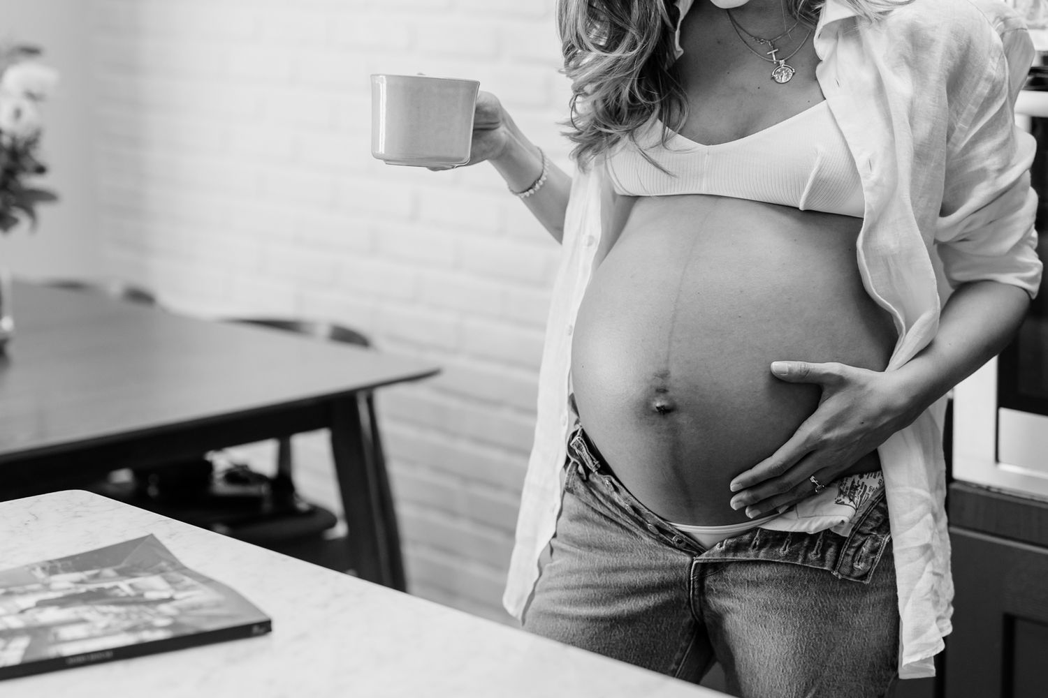 Black and white maternity photos capturing tender moments in natural light.