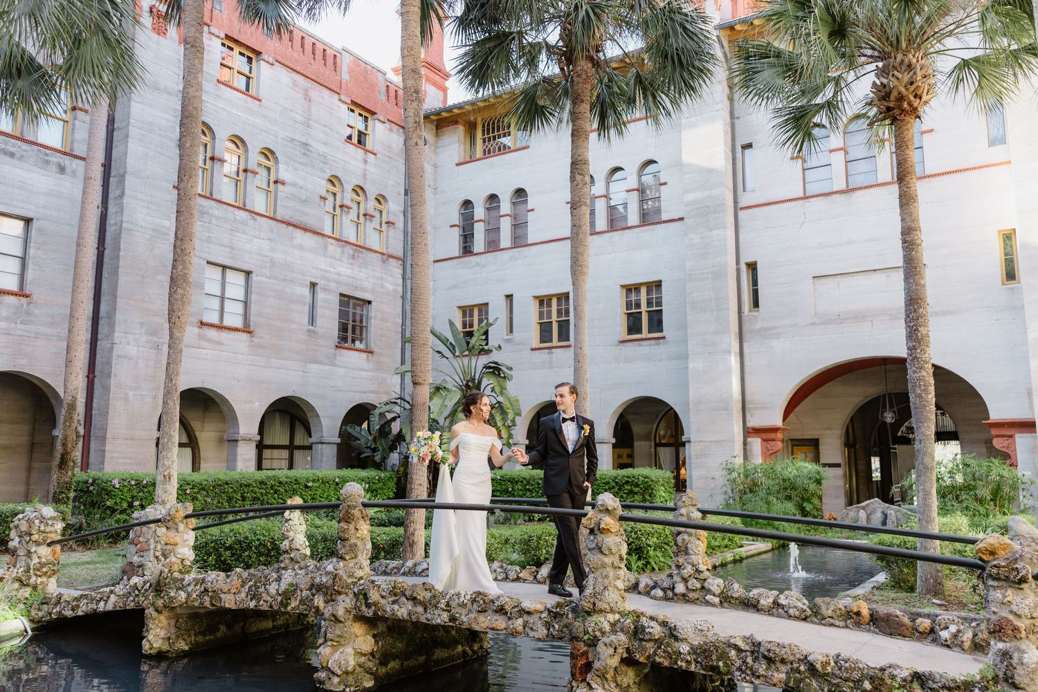 Spanish-style courtyard with palm trees and elegant white arched walkways along the perimeter.