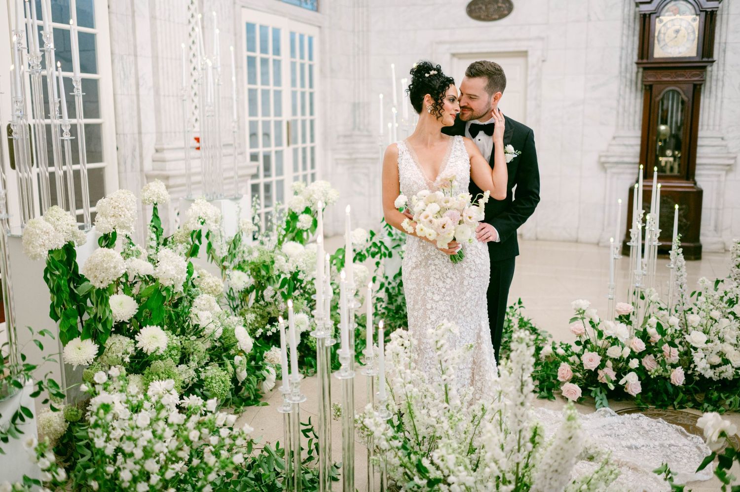 Just married couple embracing at elegant wedding venue with period artwork and windows at the DAR Constitution Hall in Washington DC.