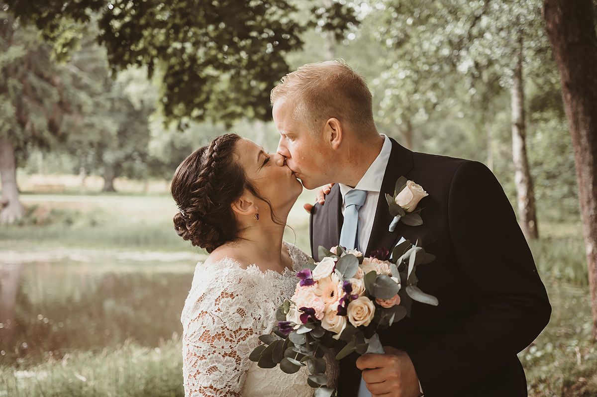 Bröllopsfoto på brudpar i grönskan på Medevi Brunn, bröllopsfotograf Lets Bloom Media i Östergötland.