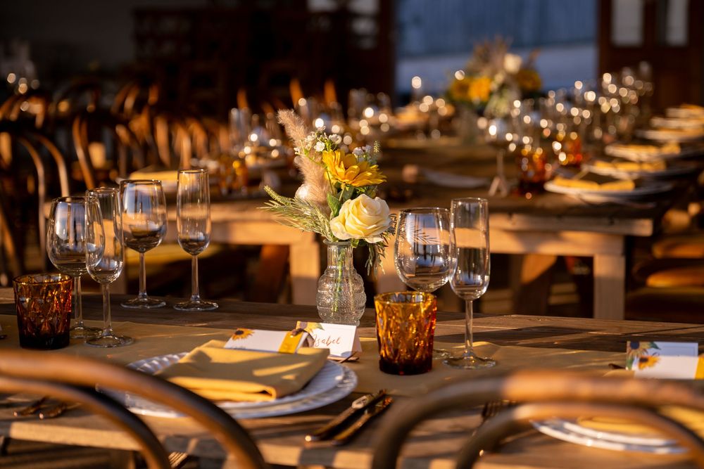 Elegant dinner table setting with wine glasses, floral centerpiece, and warm candlelight at a formal event.