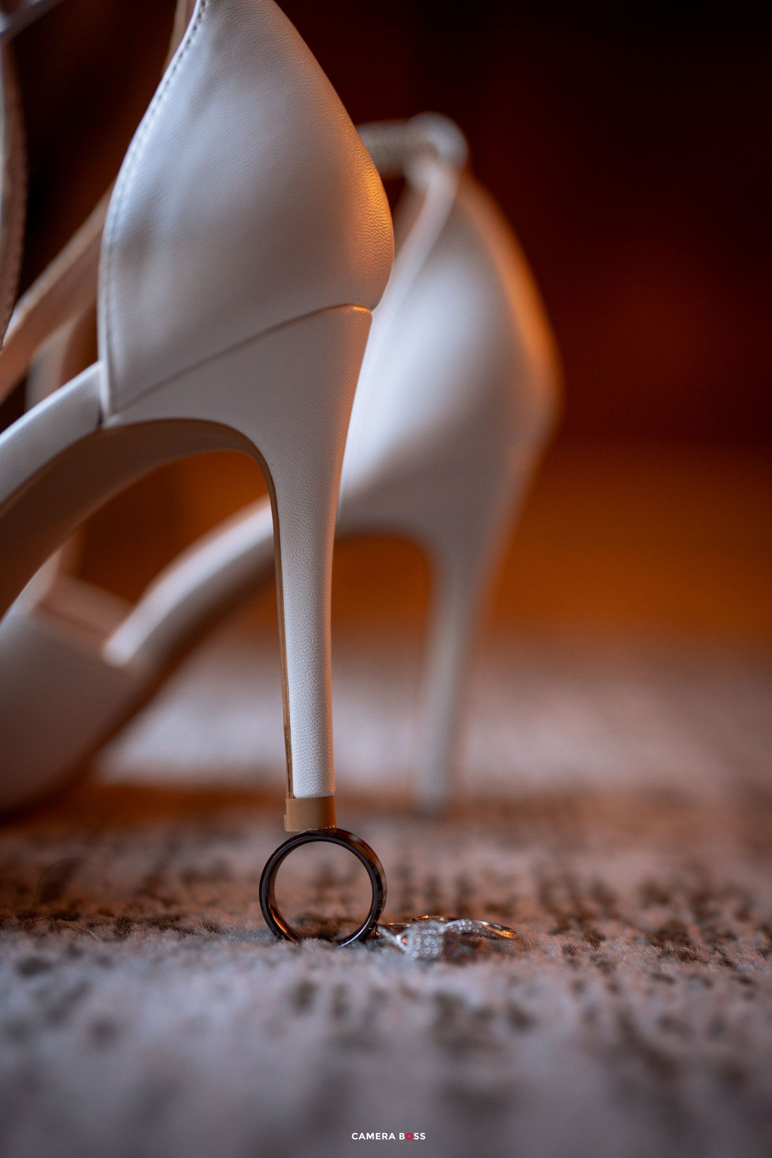 A white high heel shoe stepping on a textured carpet surface shown in a sequence of close-up shots.