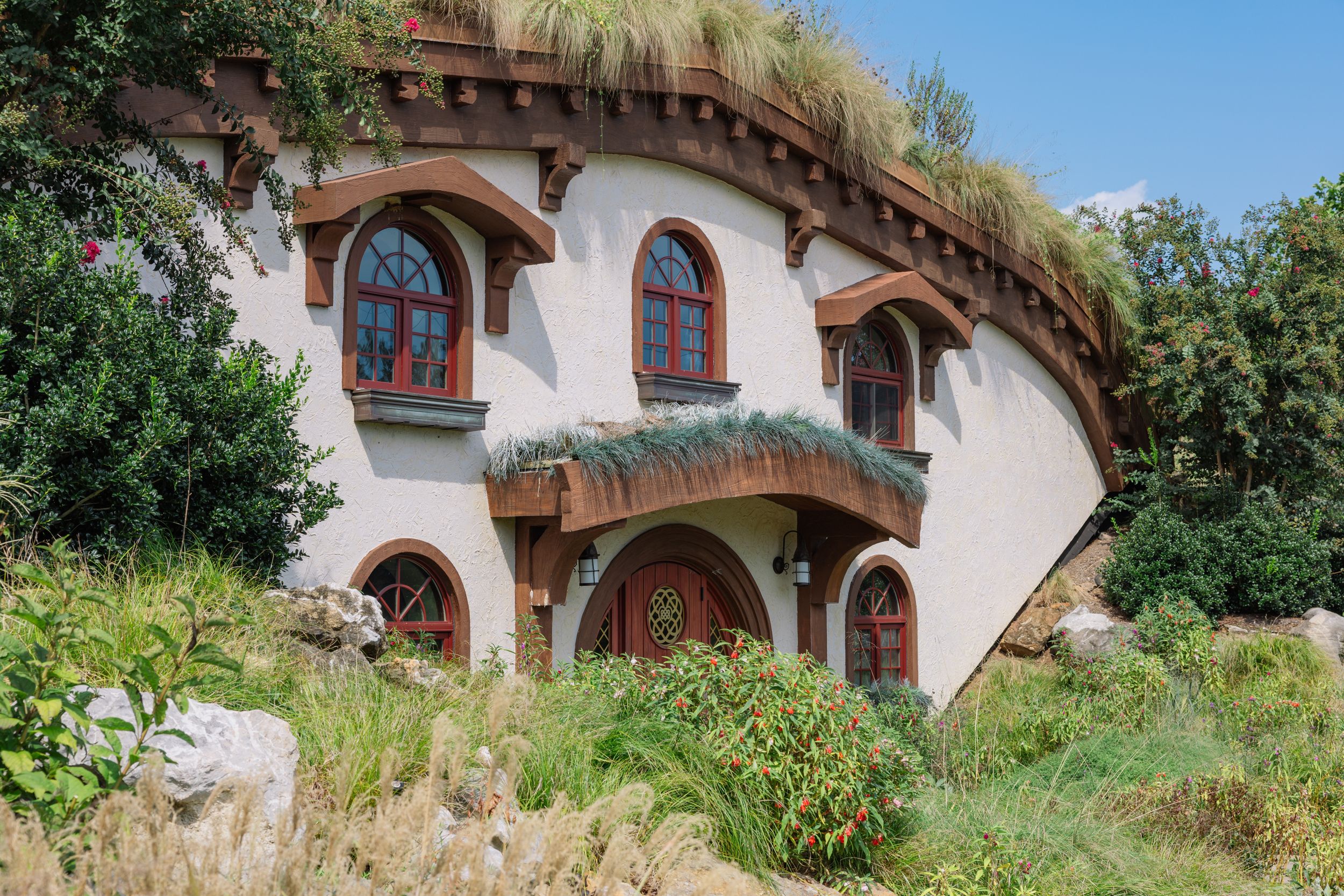Hobbit-style earth home with arched windows and grass roof at Ancient Lore Village, a fantasy wedding venue near Knoxville, Tennessee.
