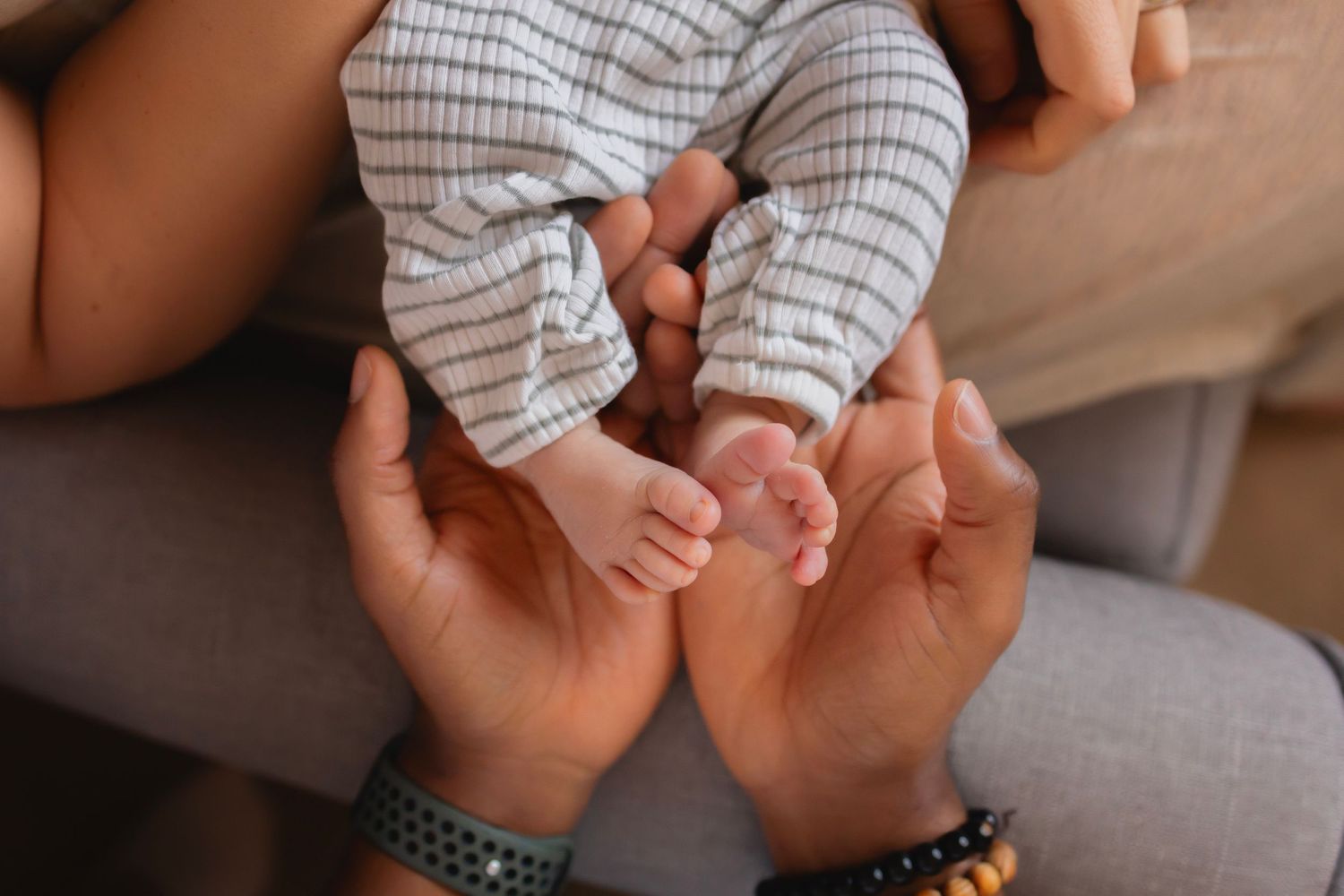 Birds eye view male hands cupping newborn feet, castle rock newborn lifestyle photographer