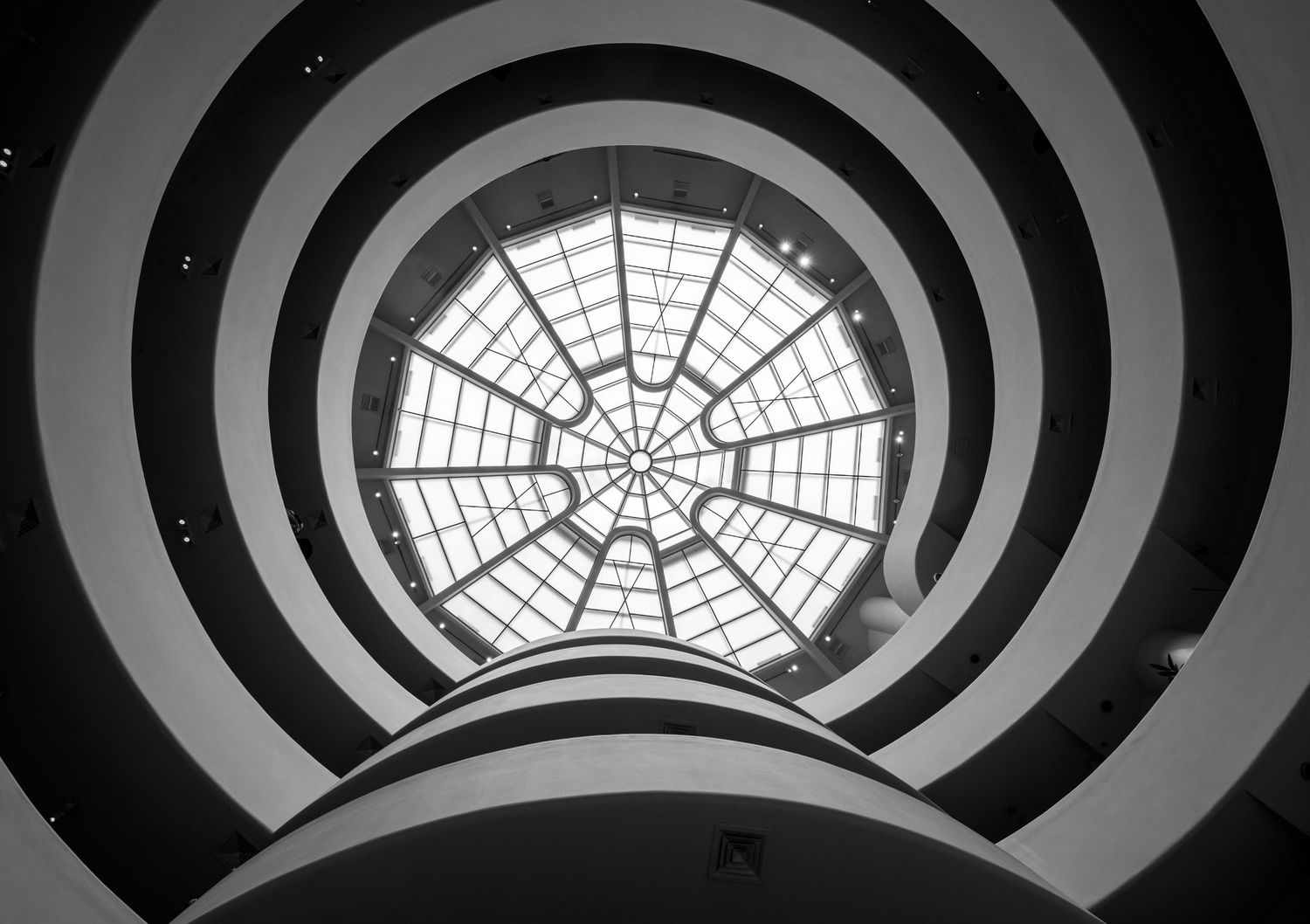 Architectural detail of a spiral skylight pattern in black and white with concentric circles and geometric design.