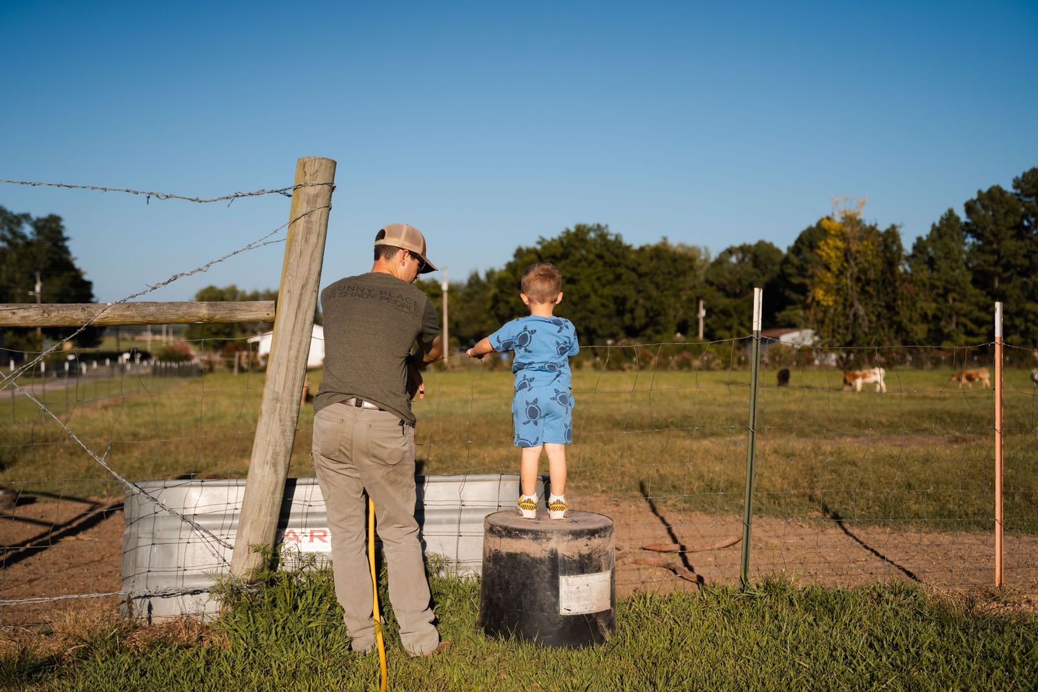 Little boy helping dad with chores during documentary family photography session by Tulsa photographer