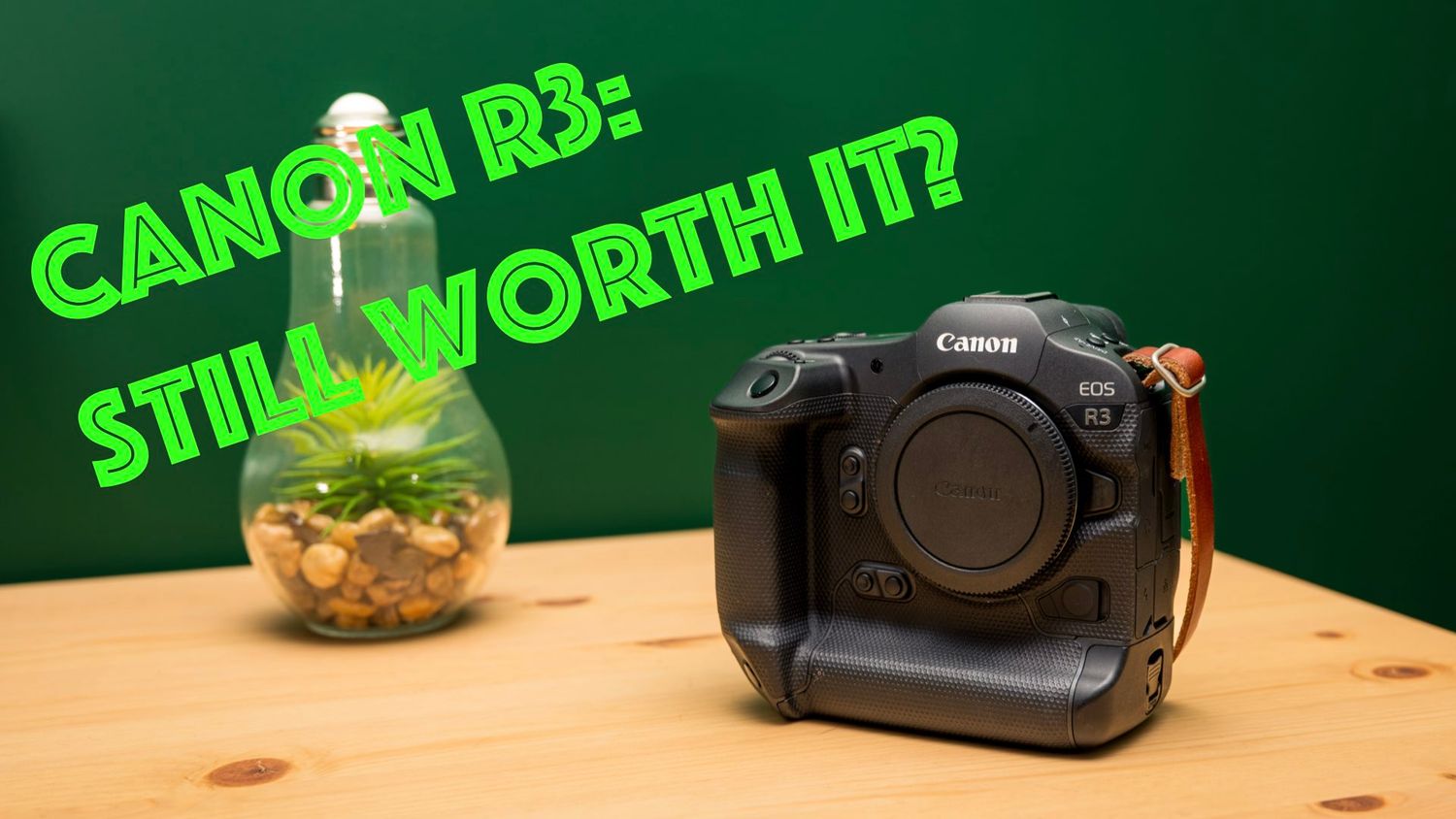 Canon R3 mirrorless camera sits beside a glowing pineapple decoration on wooden table with green text overlay.