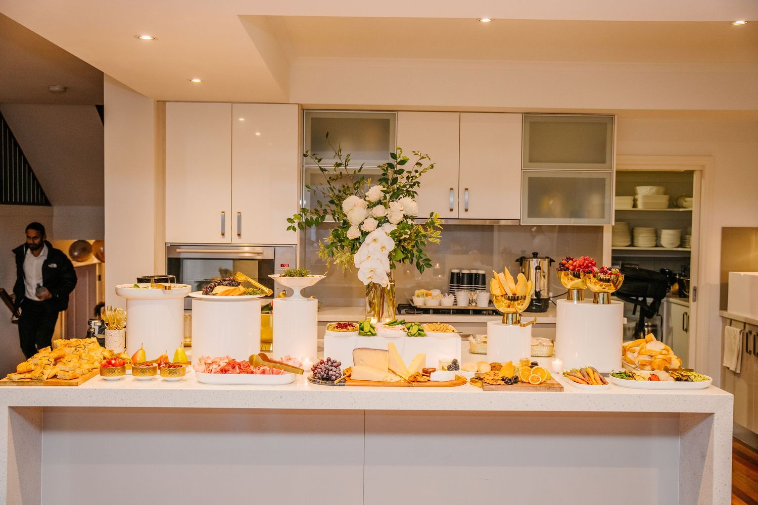 Long buffet table set up at a special event with colorful appetizers and snacks spread across multiple stations.