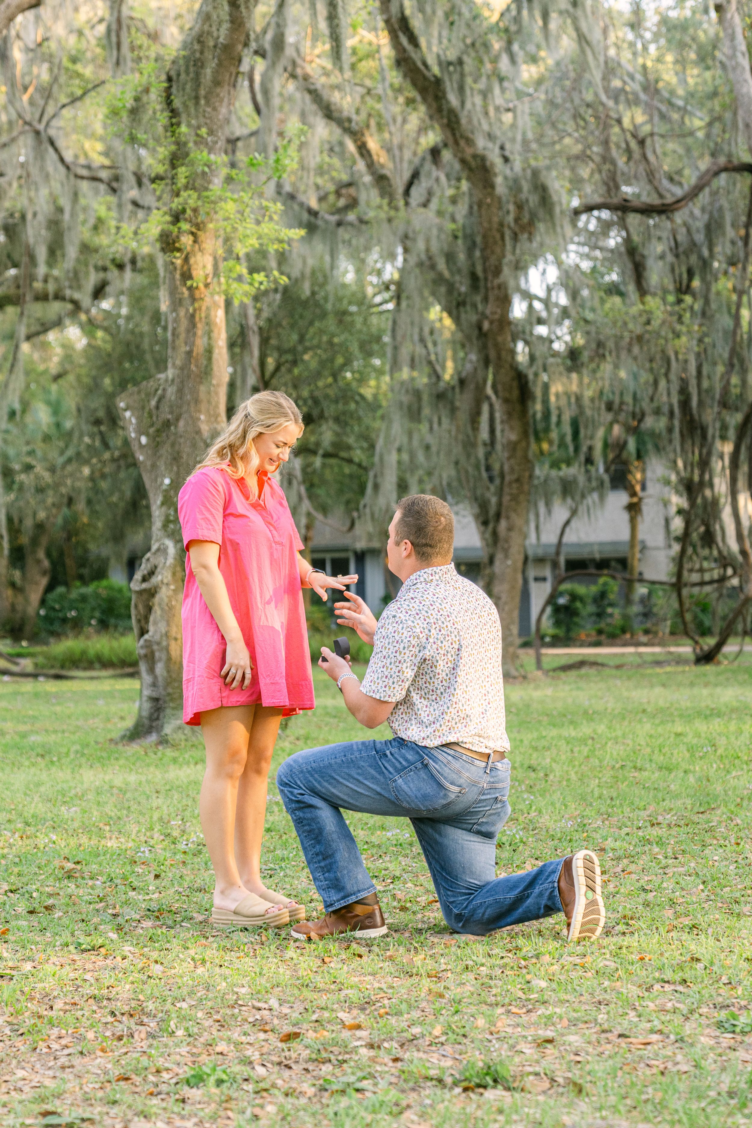 Young couple happy and engaged during a surprise golden hour engagement and proposal on Saint Simons Island, Georgia at Mallory Park