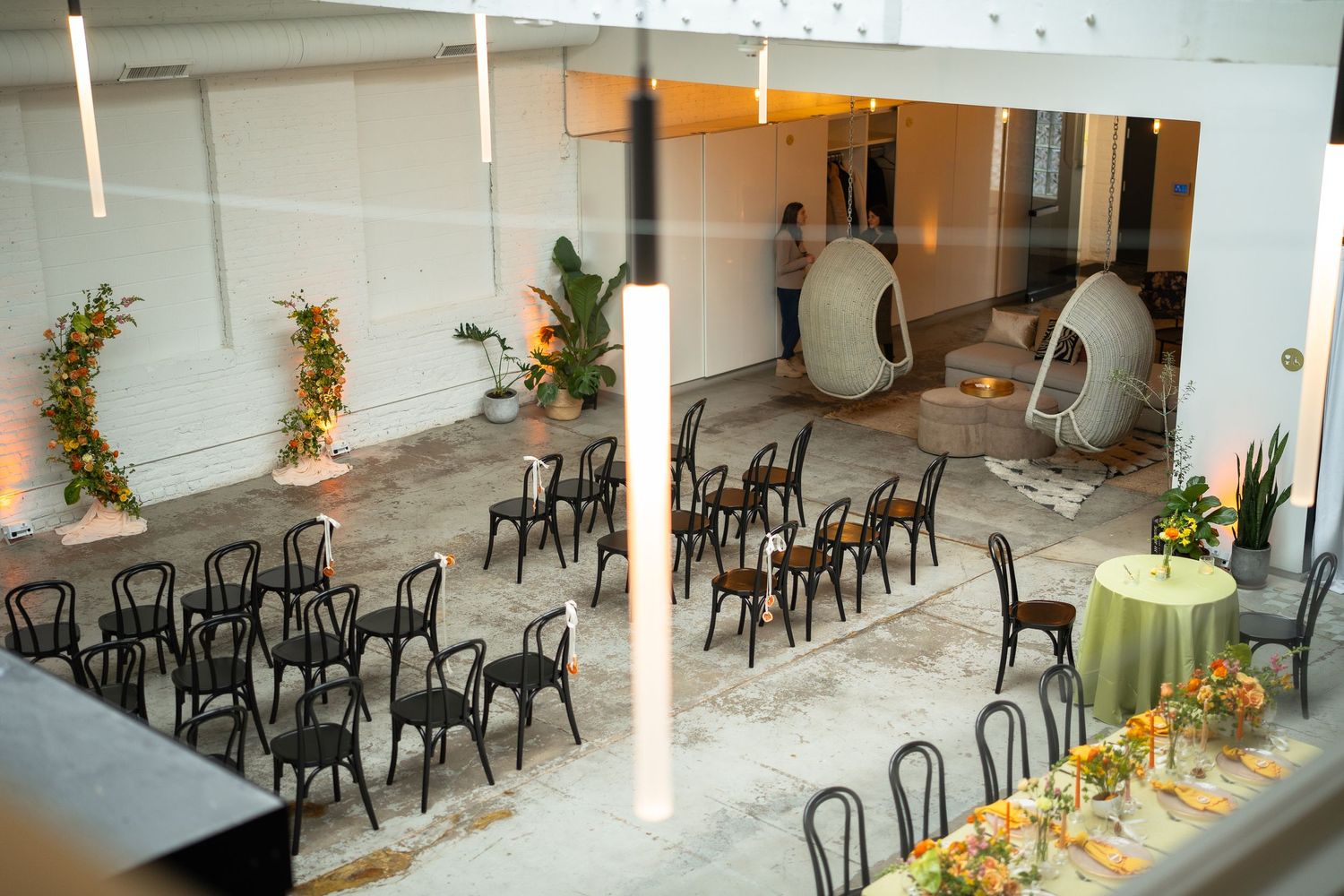 Modern event space with black chairs and yellow table settings arranged in neat rows.
