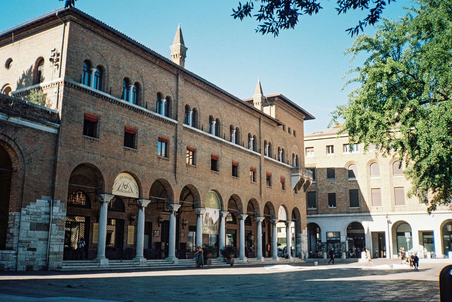 Historic arcade building with arched colonnade and traditional Italian architecture.