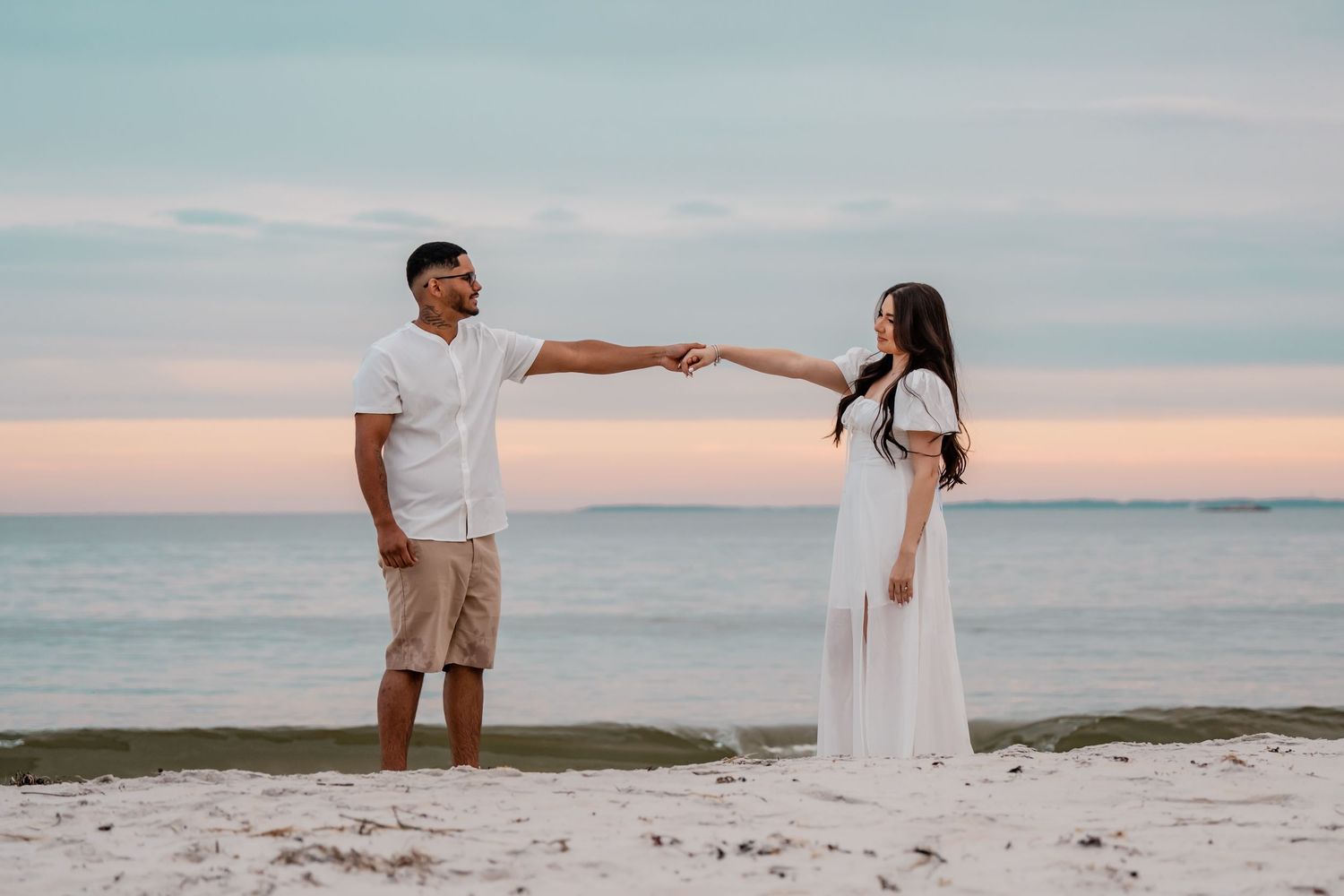 Memory Lane Studios romantic beach engagement photoshoot with couple in white outfits at sunset by wedding photographer Tharun Palla