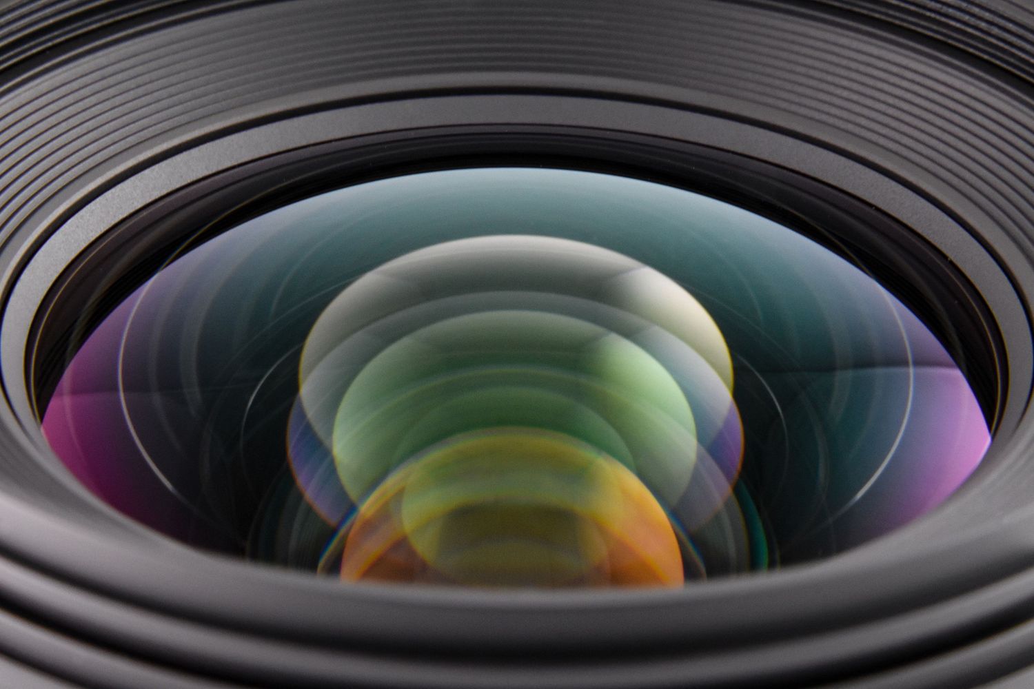 Close up of Sigma lens. Overlapping multi color - yellows, greens, purples, oranges of the lens element reflections