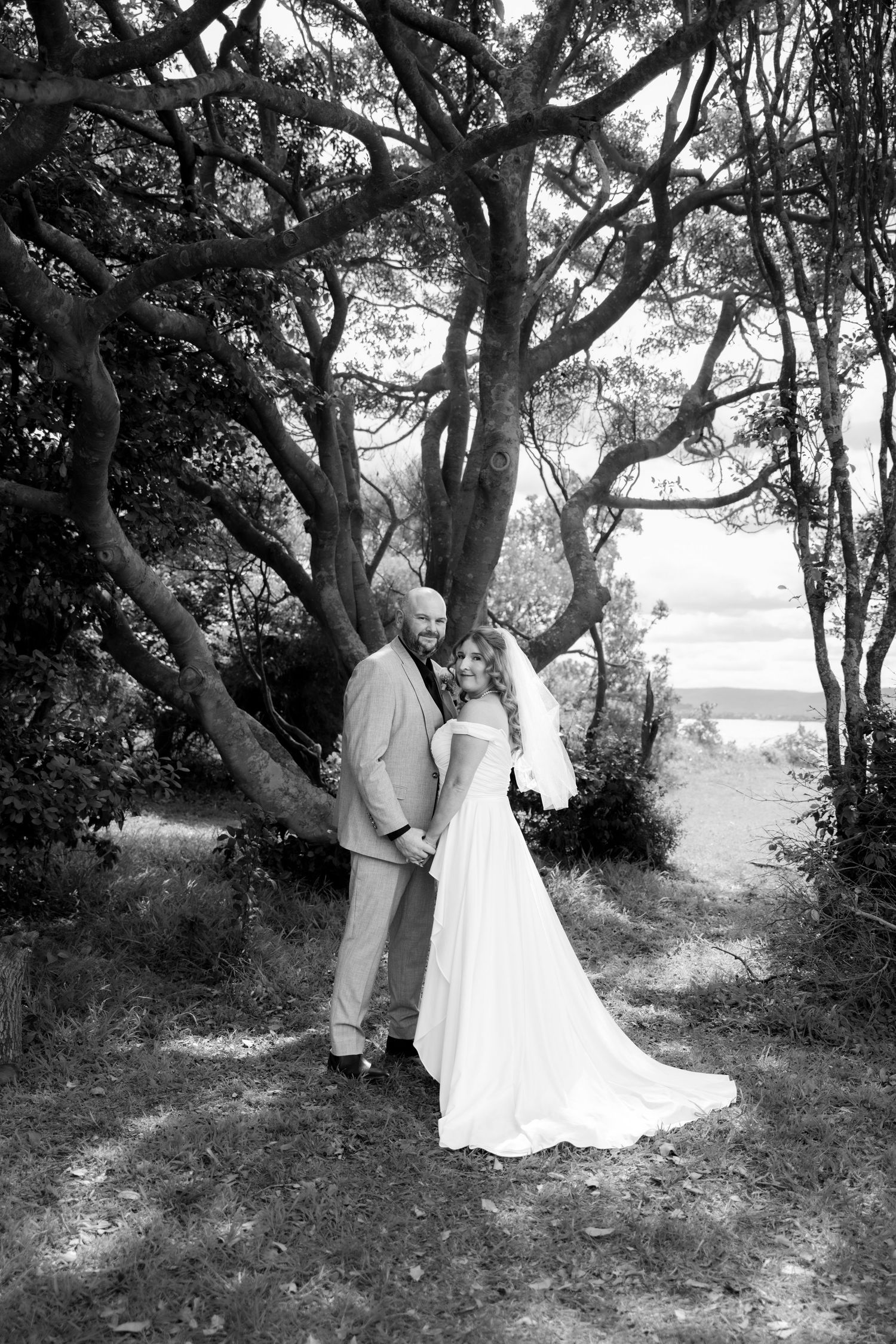 Bride and groom under twisted coastal trees by the water - intimate coastal elopement, Wollongong elopement photographer