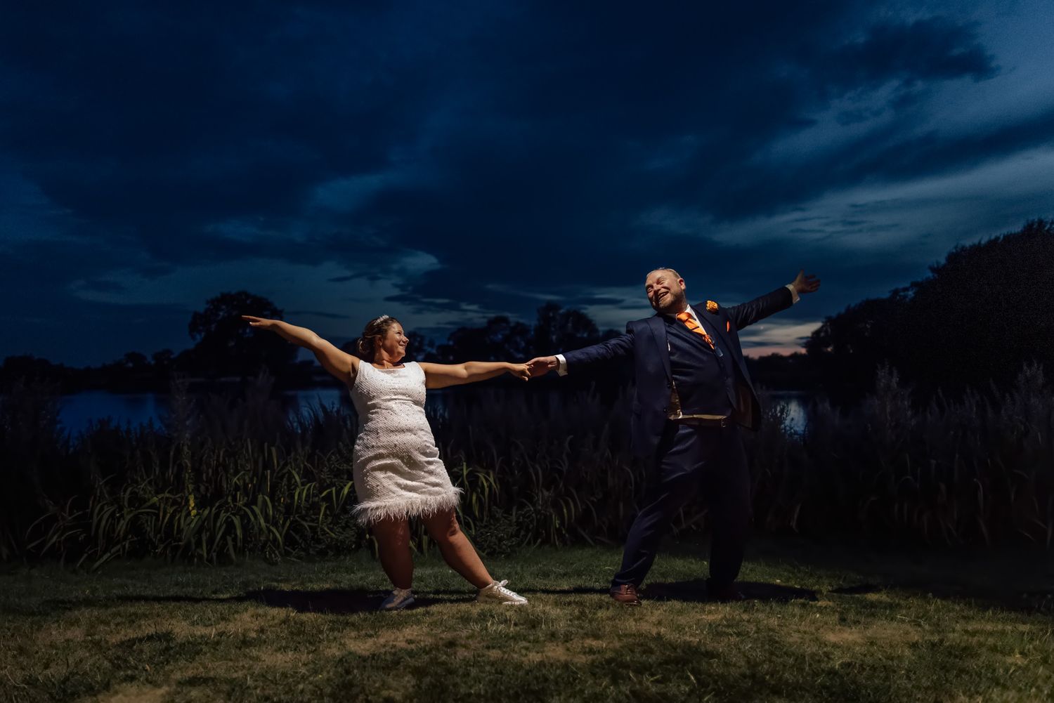 Stunning formal garden with fountain under dramatic cloudy sky at elegant wedding venue.