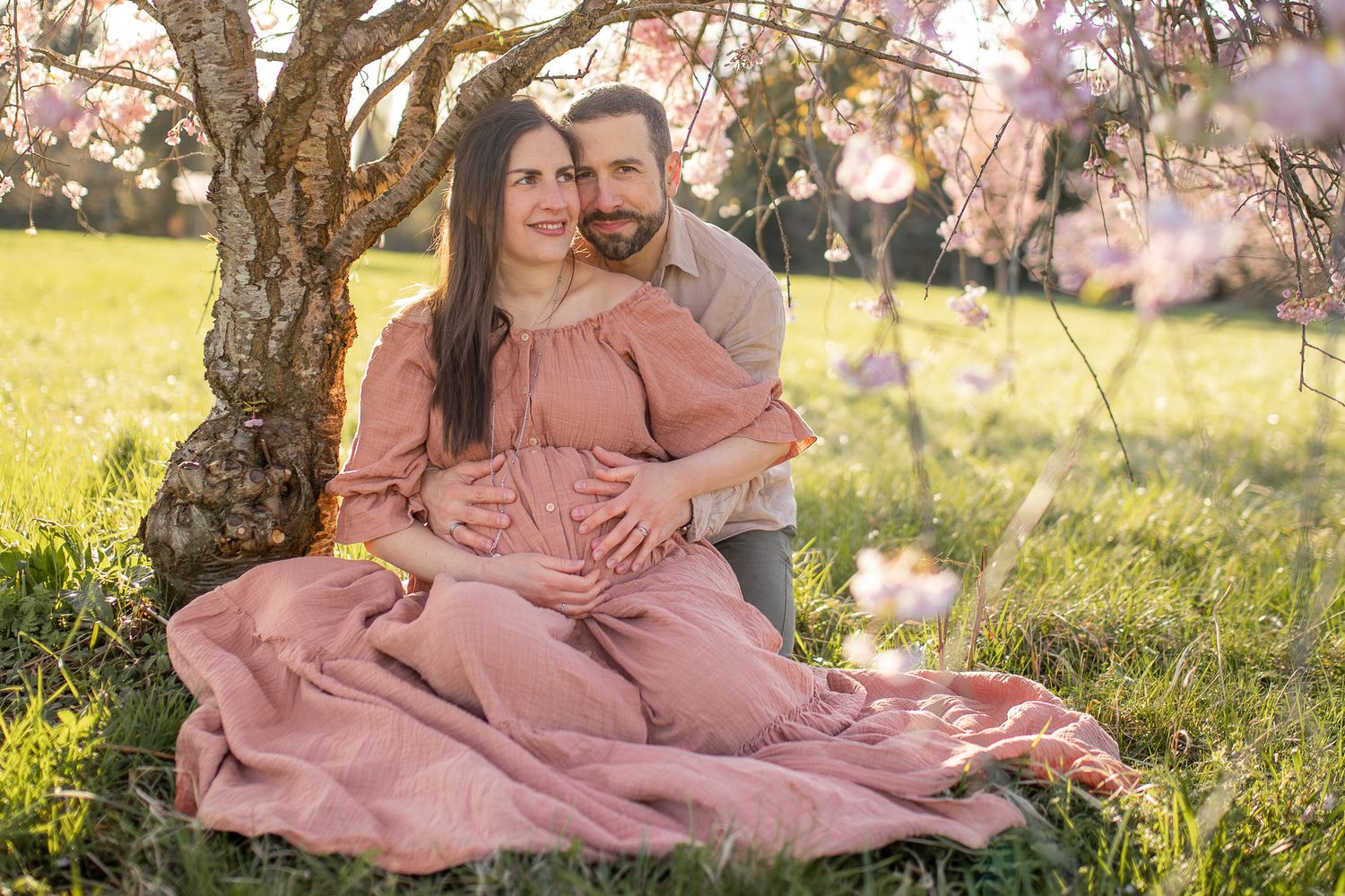 Séance grossesse sous les cerisiers en fleurs à Versailles - couple amoureux attendant un bébé au printemps