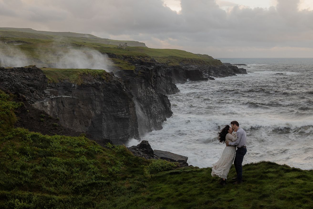 Couple embracing on Cliffs of Moher during sunrise elopement session