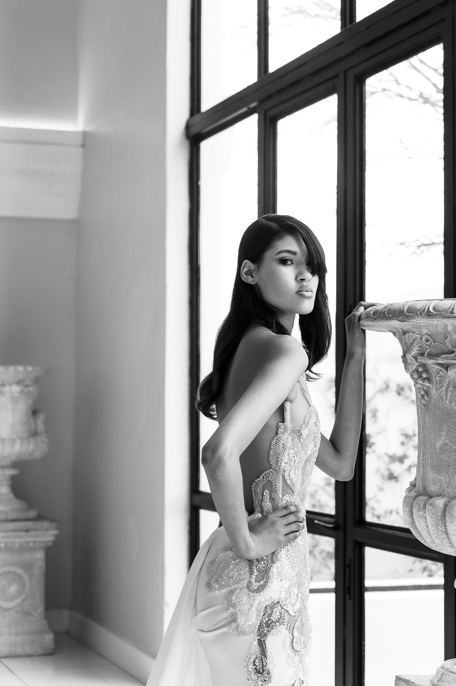 A stunning embellished wedding dress with intricate beading and ethereal design photographed in an elegant white setting.