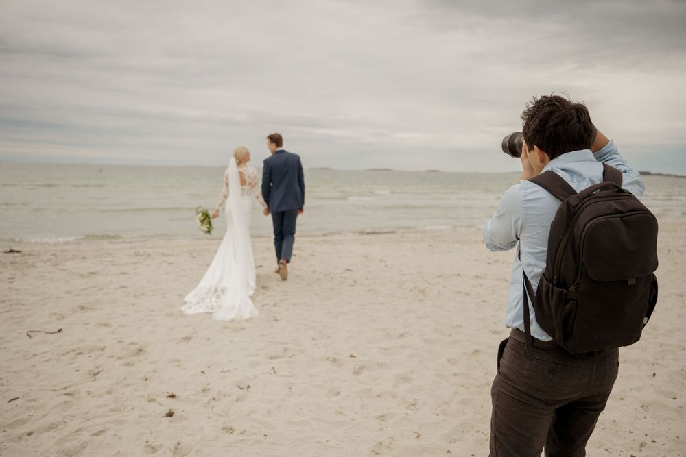 Bride in a flowing white dress twirls joyfully in a black and white photo series.