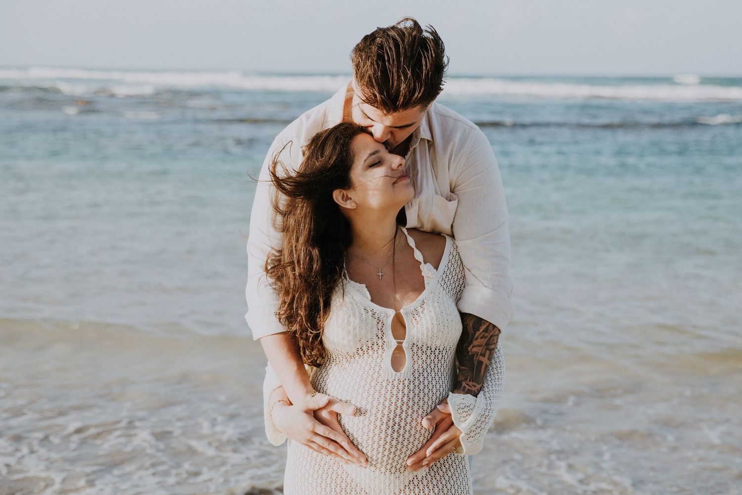 A romantic beach portrait with waves crashing in the background.