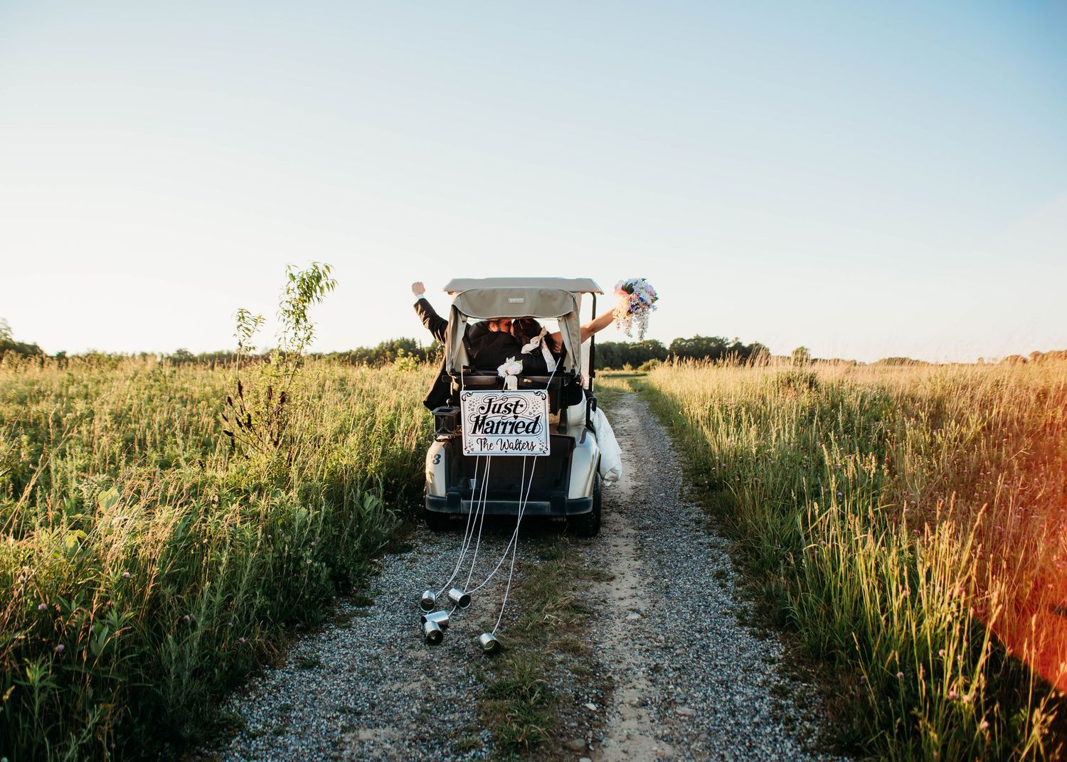 Bride and Groom at sunset in a golf cart on their wedding day in Battle creek, MI