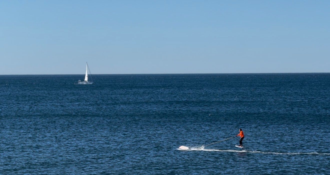A series of ocean horizon views with sailboats and blue skies over calm waters stretching to the distant horizon.