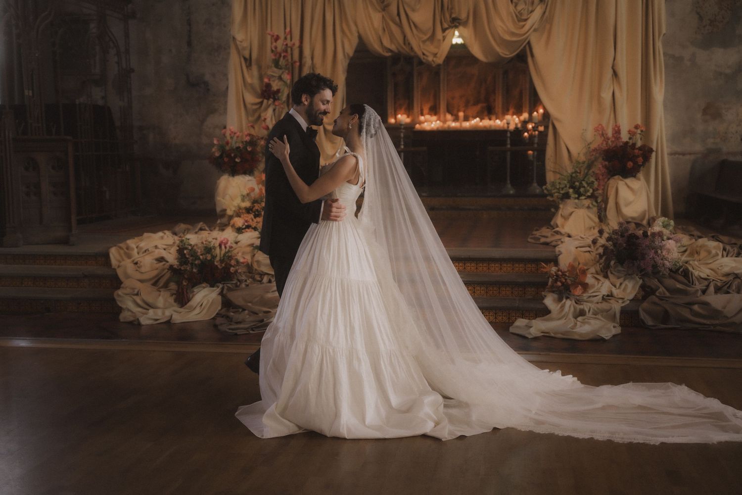 A bride in a white veil and wedding dress is photographed in a series of romantic poses during a photo session.