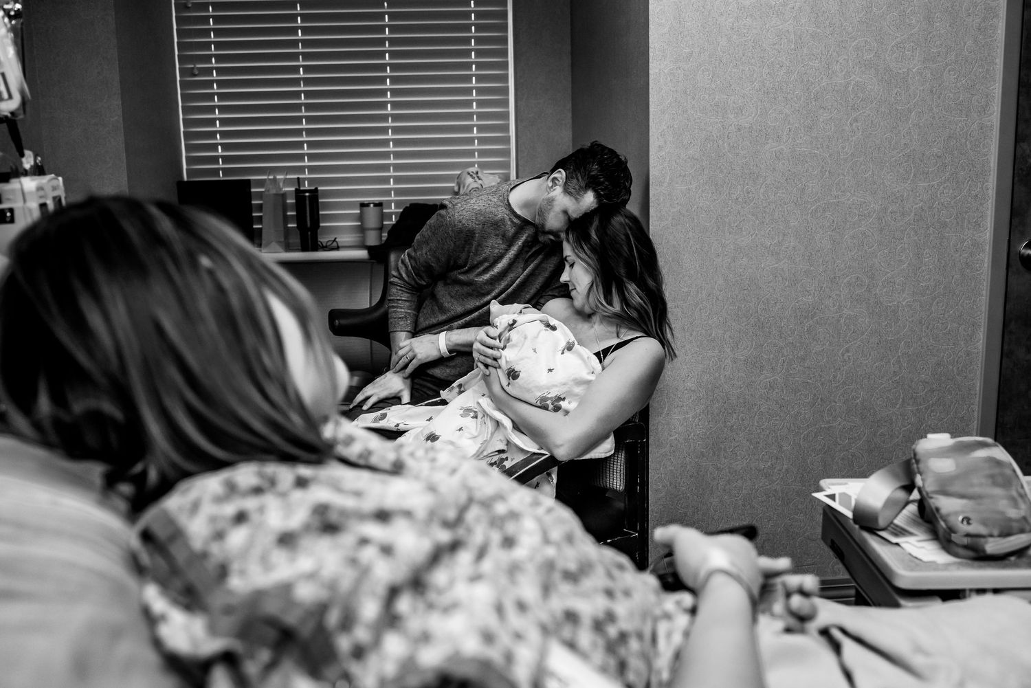 An intimate black and white photograph captures a significant moment during labor.