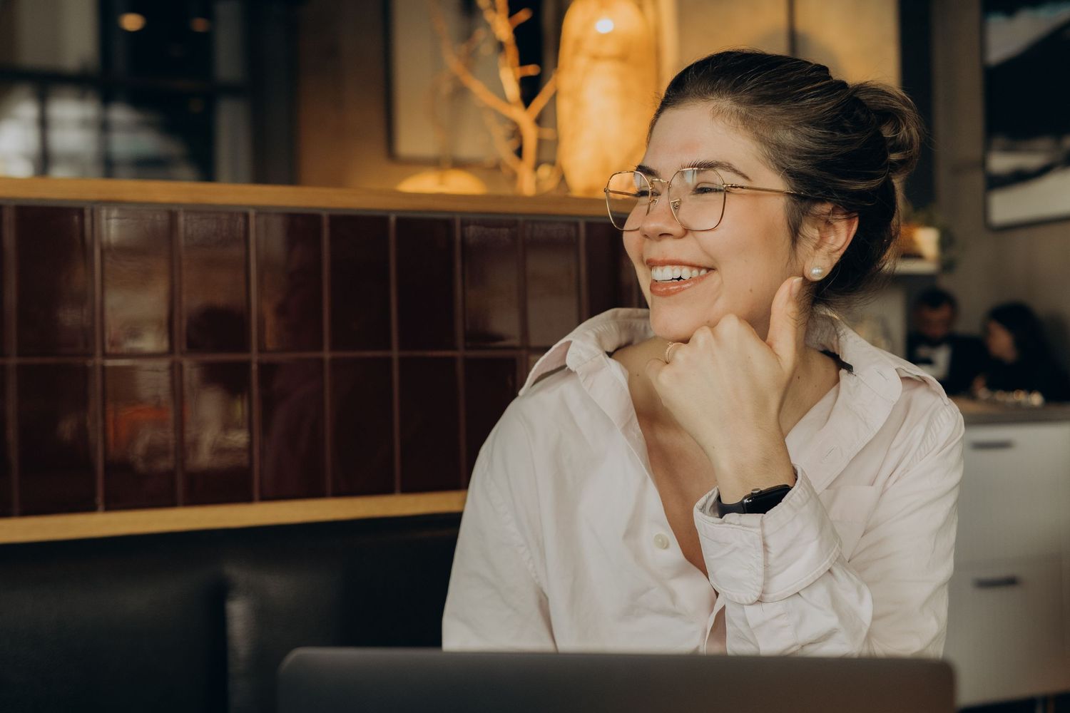event manager sitting in a café smiling while being captured by business photographer in Stockholm