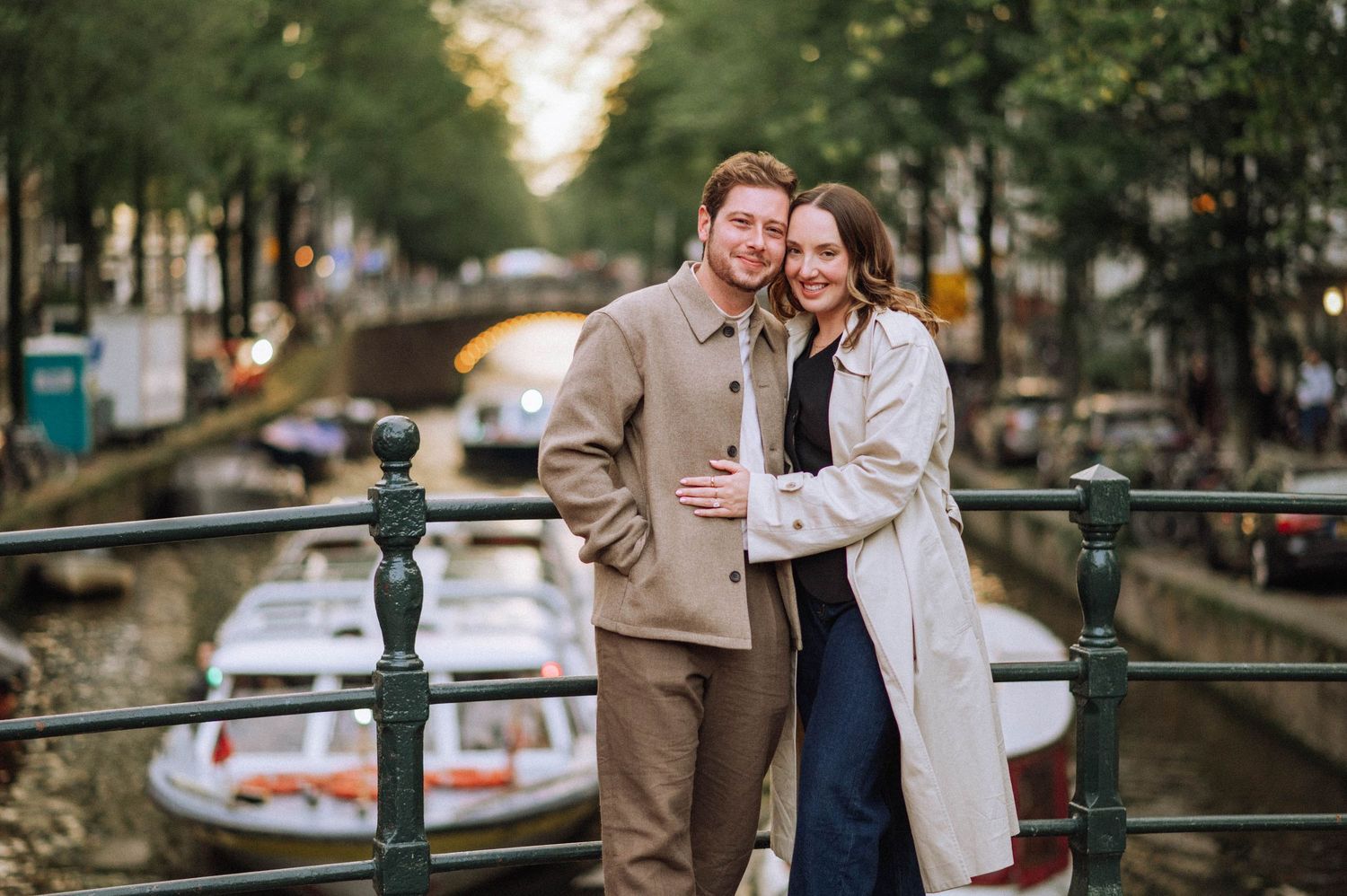 Happy couple on a bridge over an Amsterdam canal after a secret proposal—she said yes.