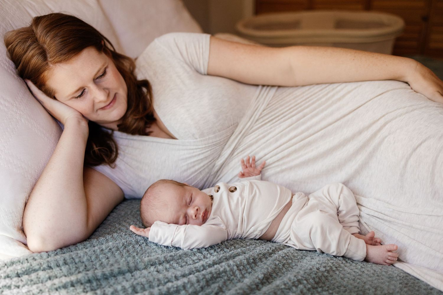 Mom snuggles next to her new baby at her in-home newborn session in Los Altos Hills