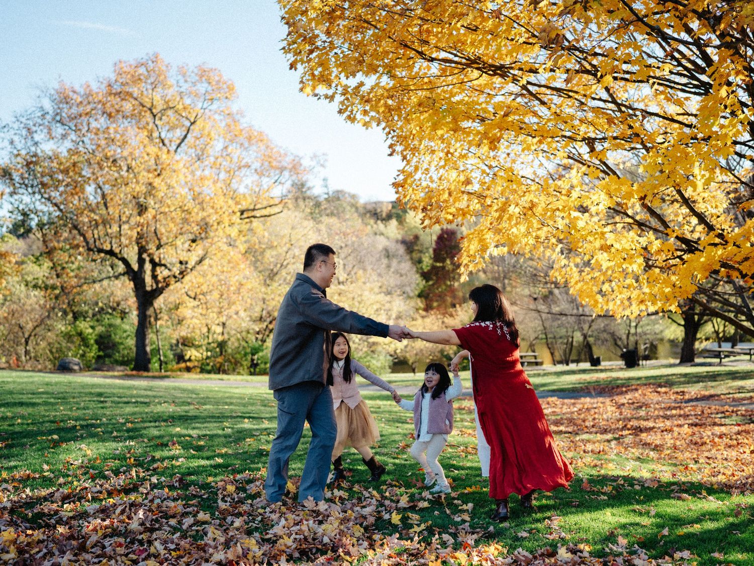 Couple shares romantic moments in a park during autumn with golden foliage and fallen leaves creating a scenic backdrop.