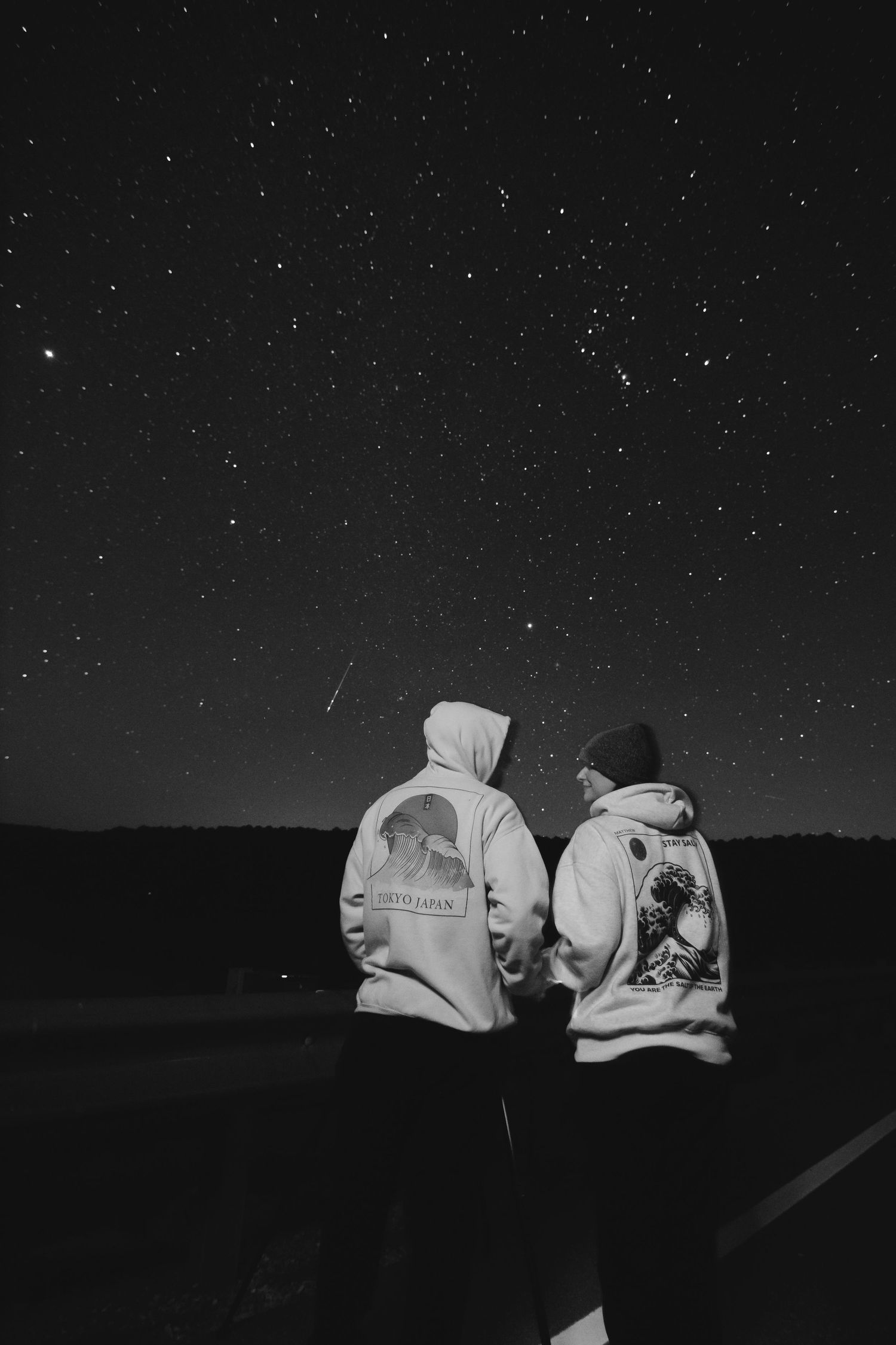 A series of black and white photos showing Jon and Heather under the night sky while a "shooting star" meteor streaks across the frame.