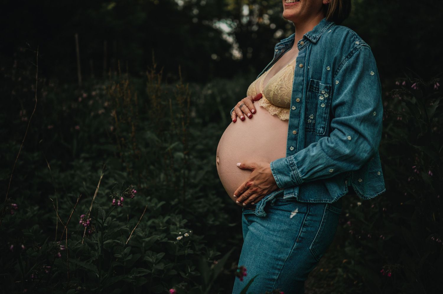 Silhouetted maternity photo sequence showing pregnancy progression against dark forest background in teal dress.