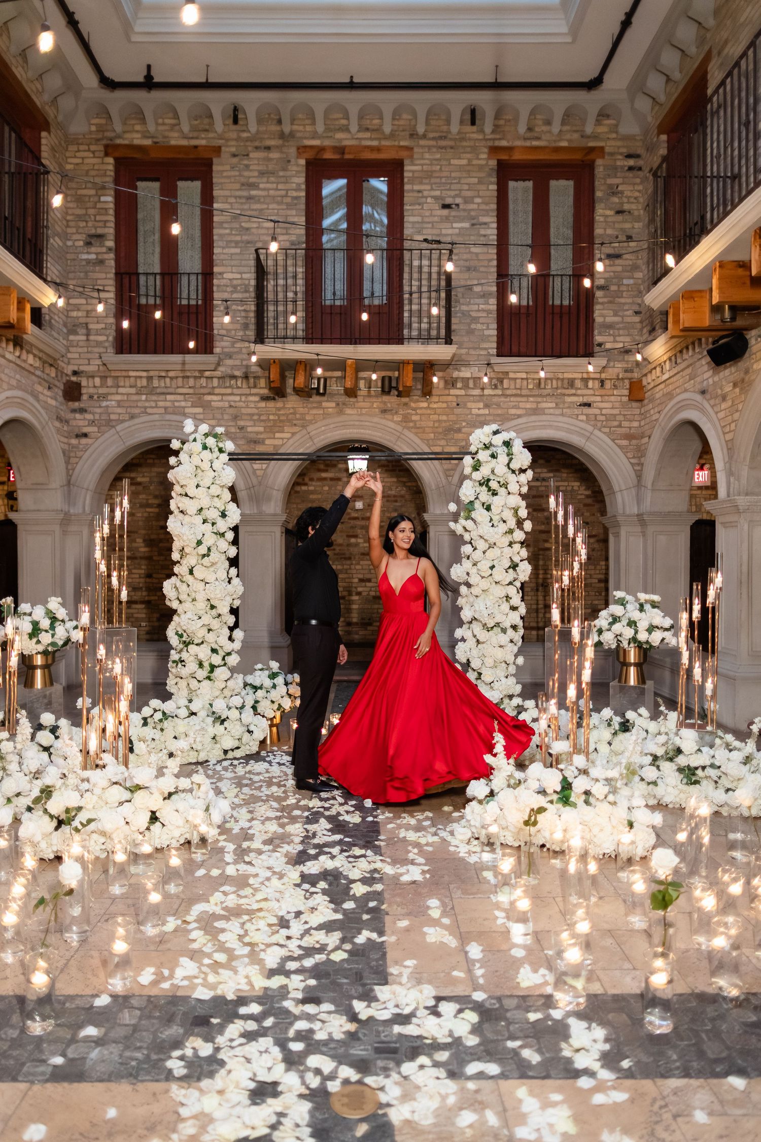 Elegant arched hallway in historic building with ornate architectural details and hanging decorative elements.