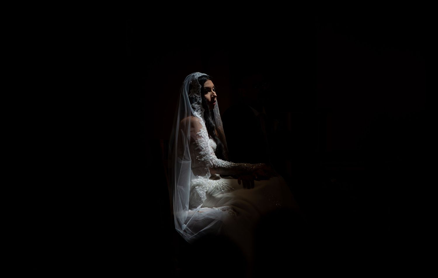A series of seven dark, moody photographs showing someone in white clothing against black backgrounds.