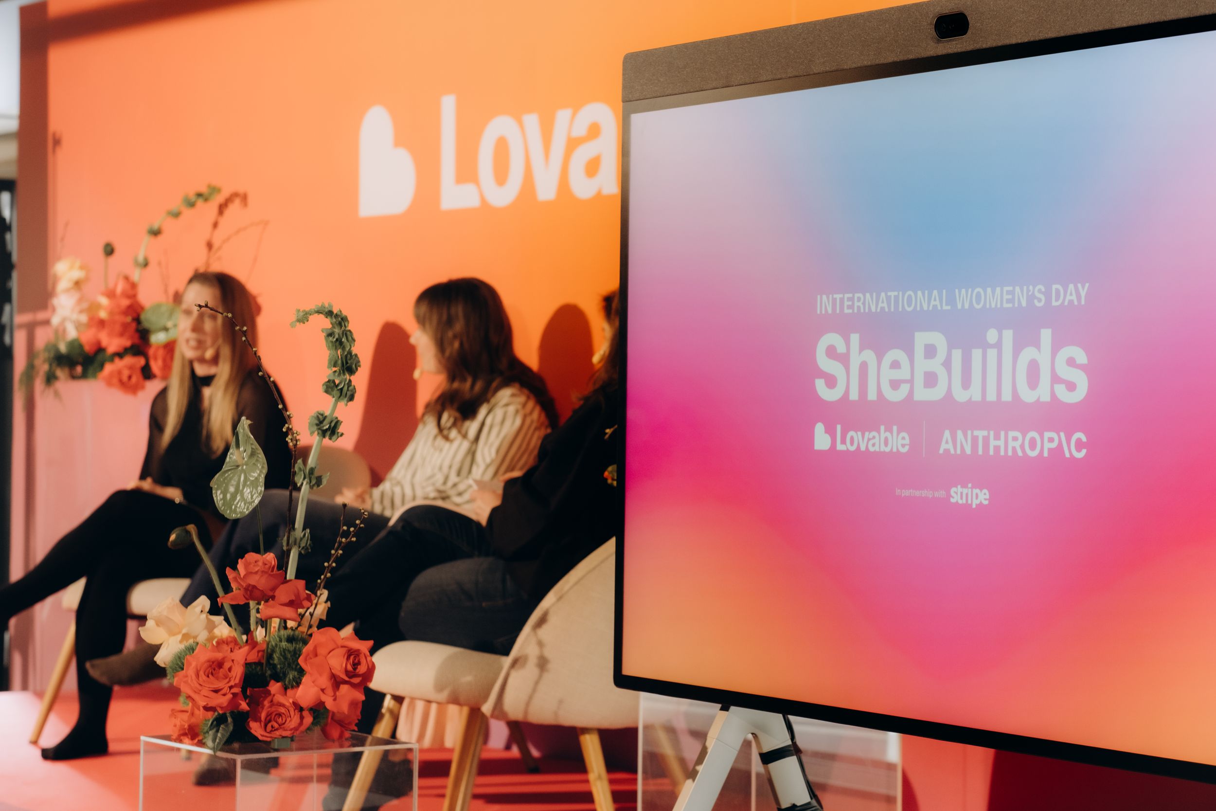 two women speaking on a stage during conference while being captured by photographer offering event photography services in Stockholm