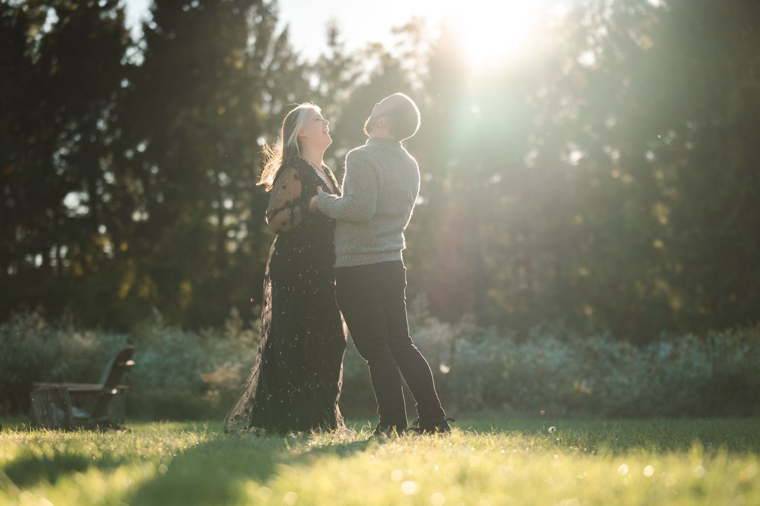 Hudson Valley wedding couple laugh and walk up hillside with fall foliage and pond behind them at Drowned Lands Brewery in Warwick, NY.