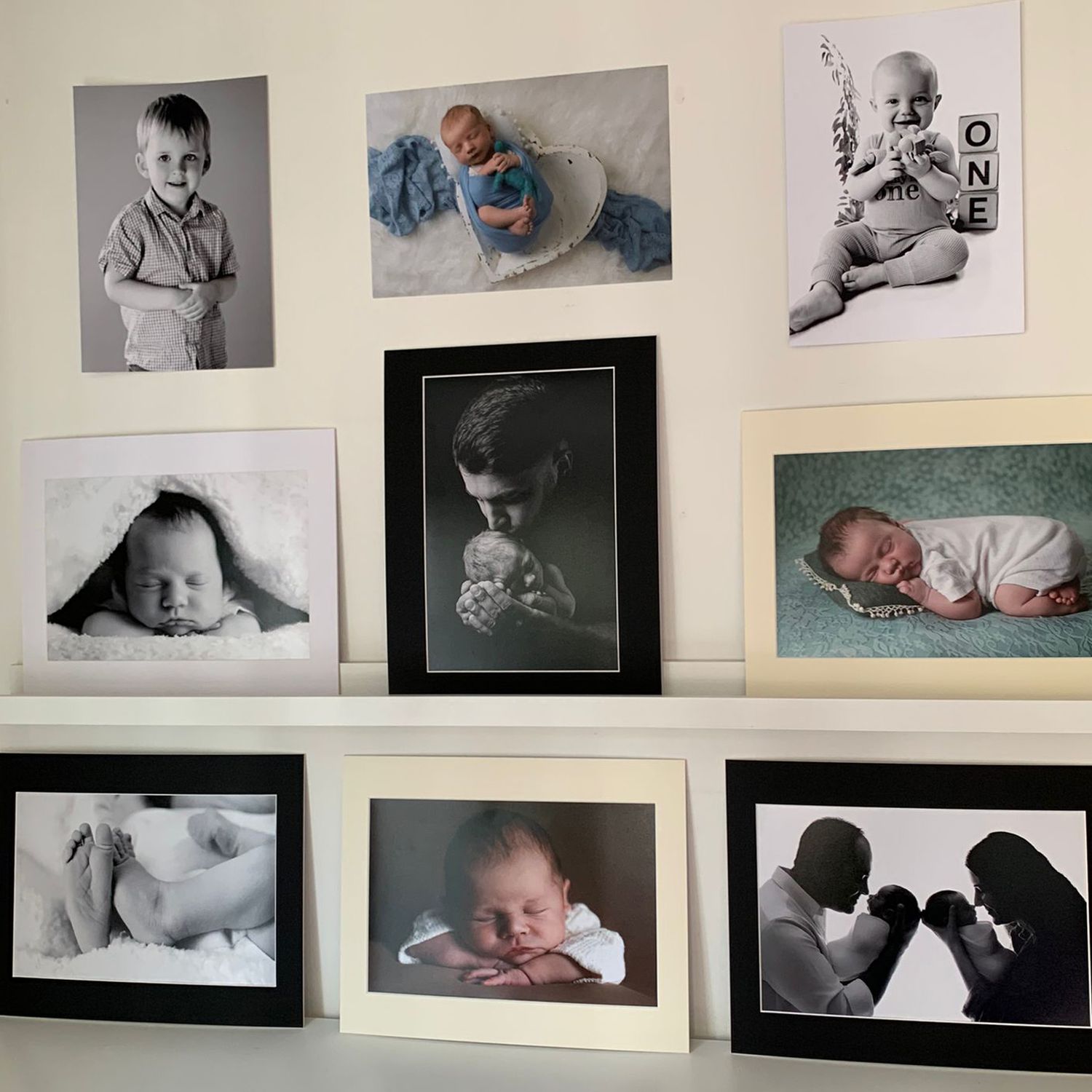 A black and white photo album shows four portrait photographs arranged on an open page including snapshots of family memories.