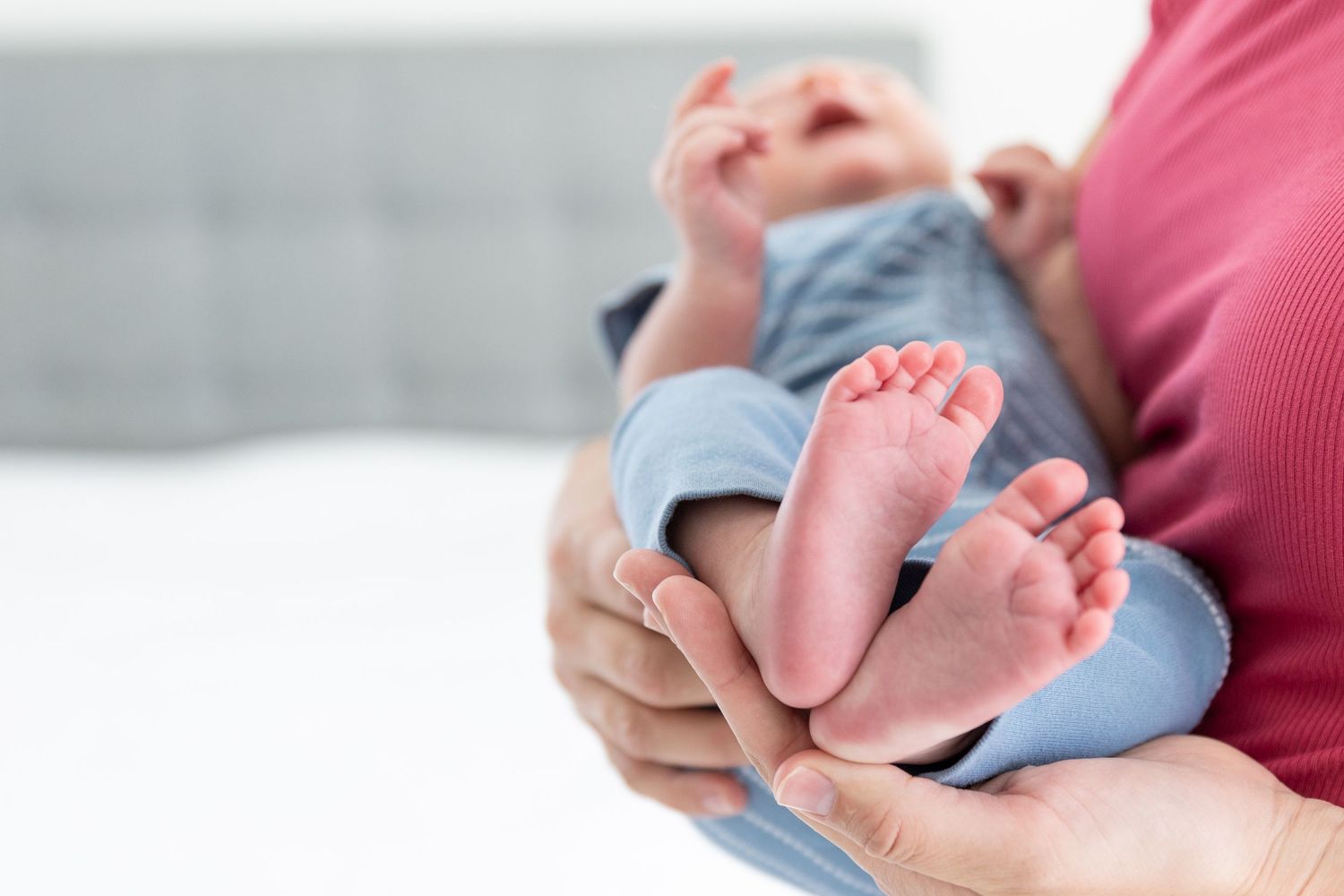newborn babies feet in moms arms