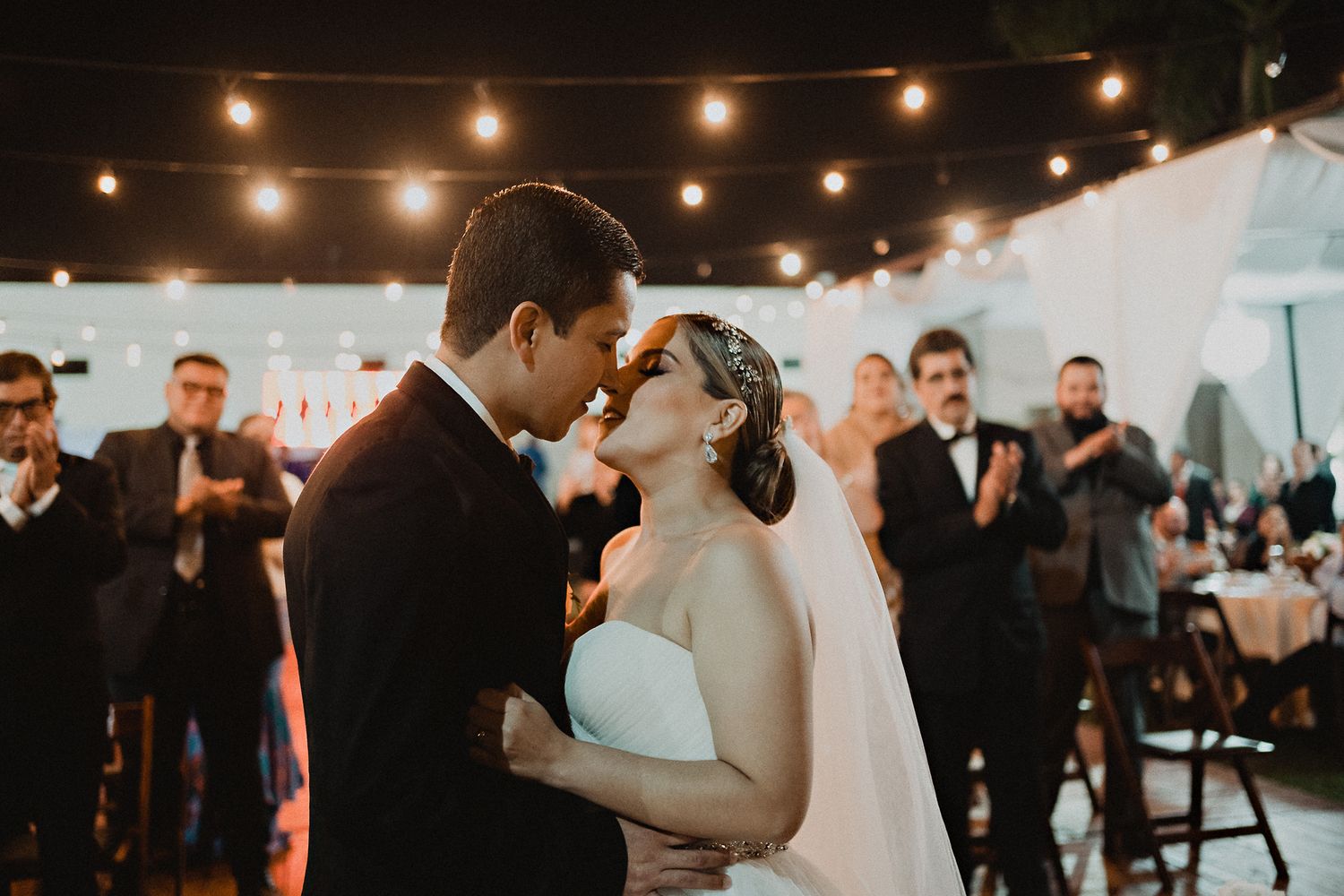 Moment before the kiss at the civil ceremony, surrounded by applauding guests, capturing a warm atmosphere