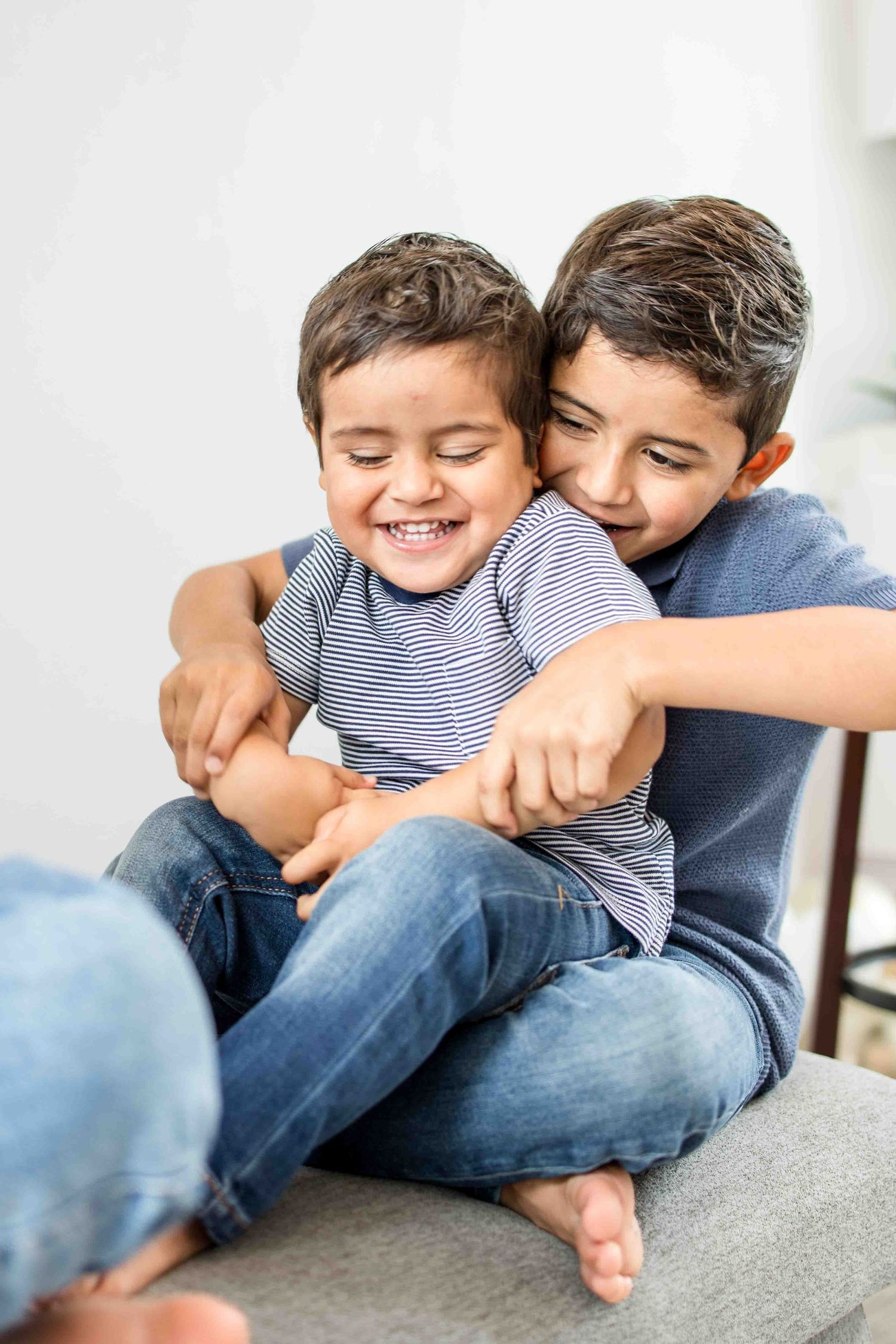 two young brothers hugging and laughing at in-home lifestyle session in north carolina