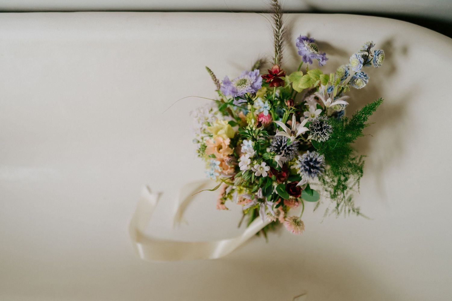 Close-up of coral garden roses and dahlias in a lush floral arrangement.