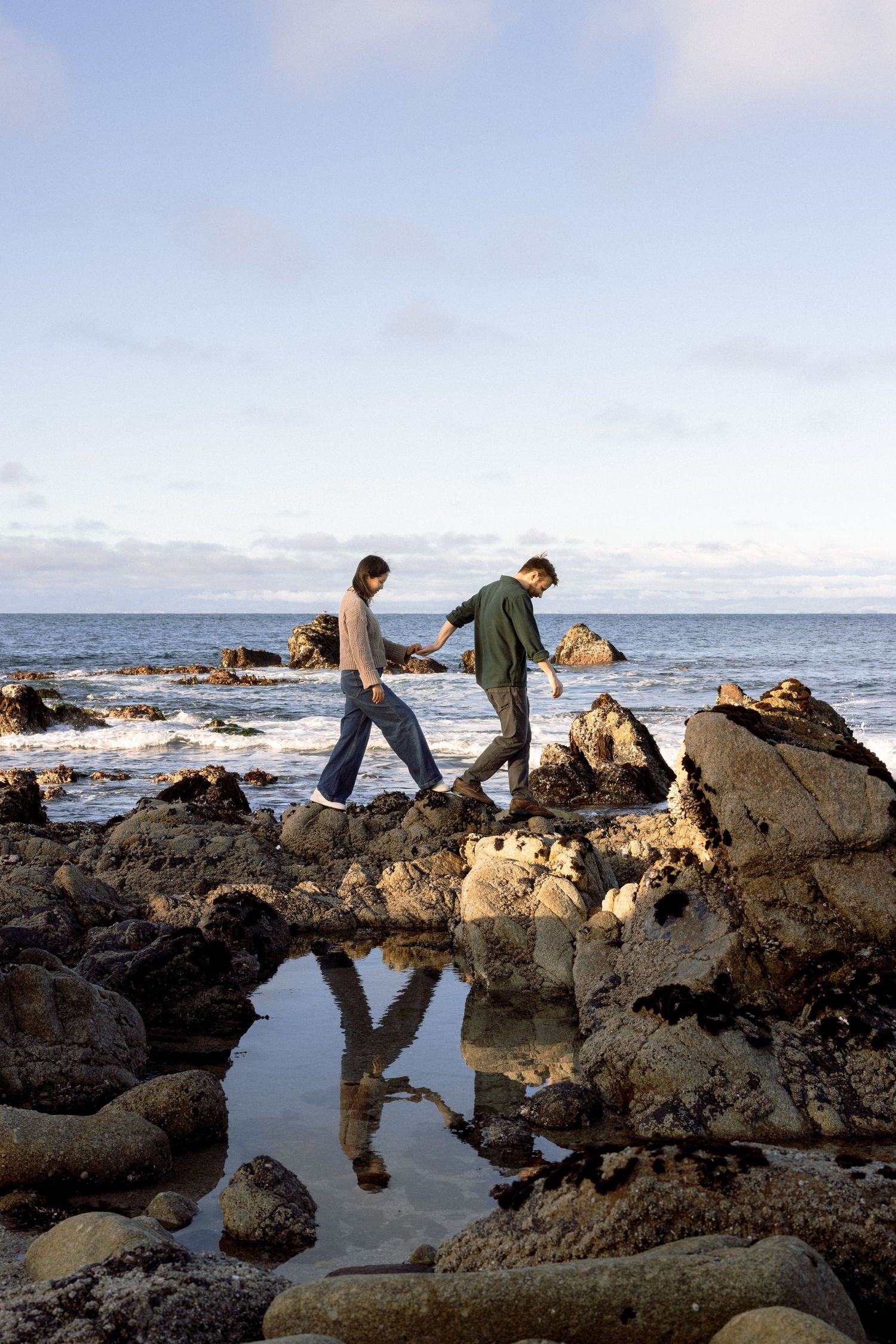 Biracial couple walks along Northern California Coast for engagement portraits