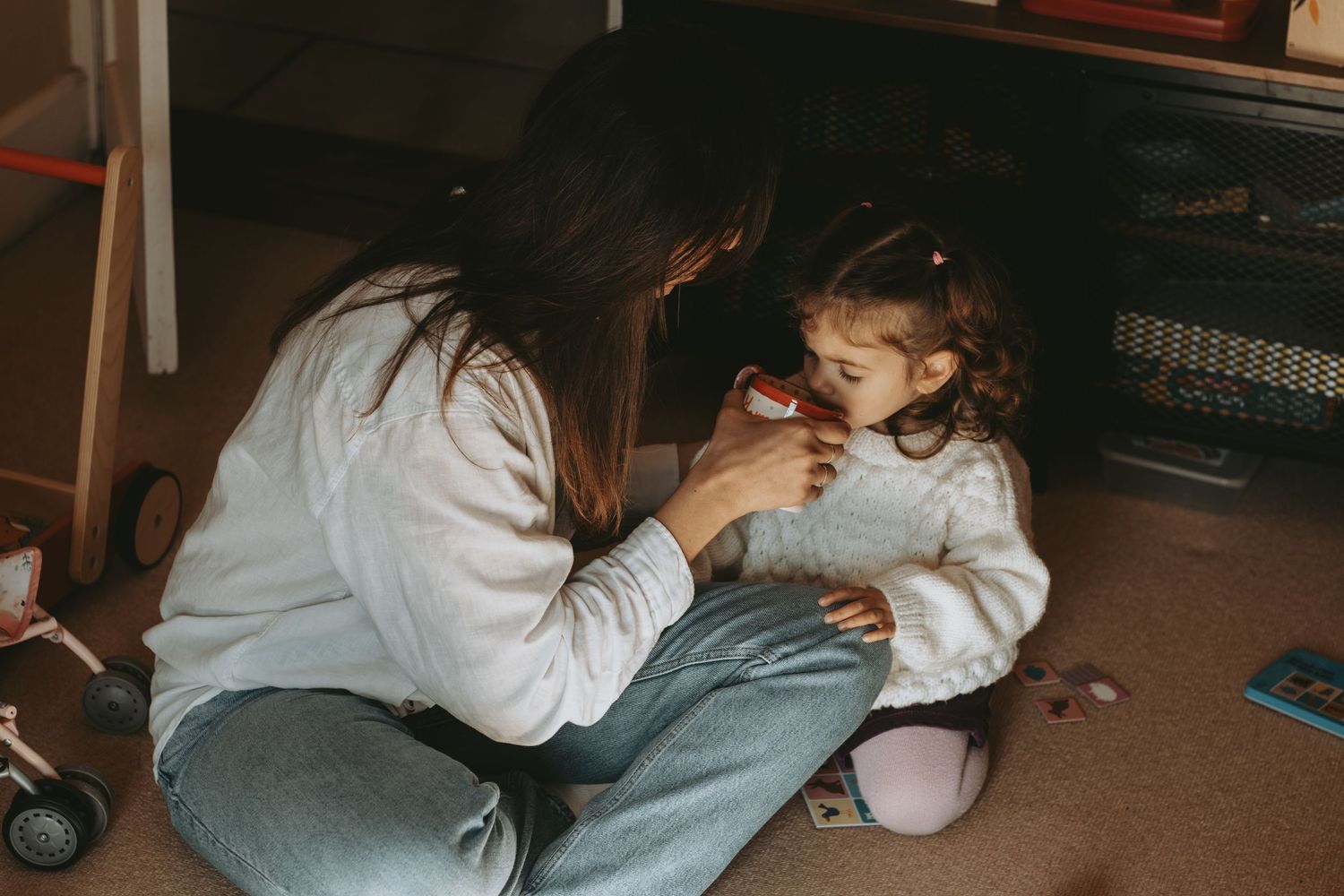 A tender moment shared between parent and child sitting on the floor at home.