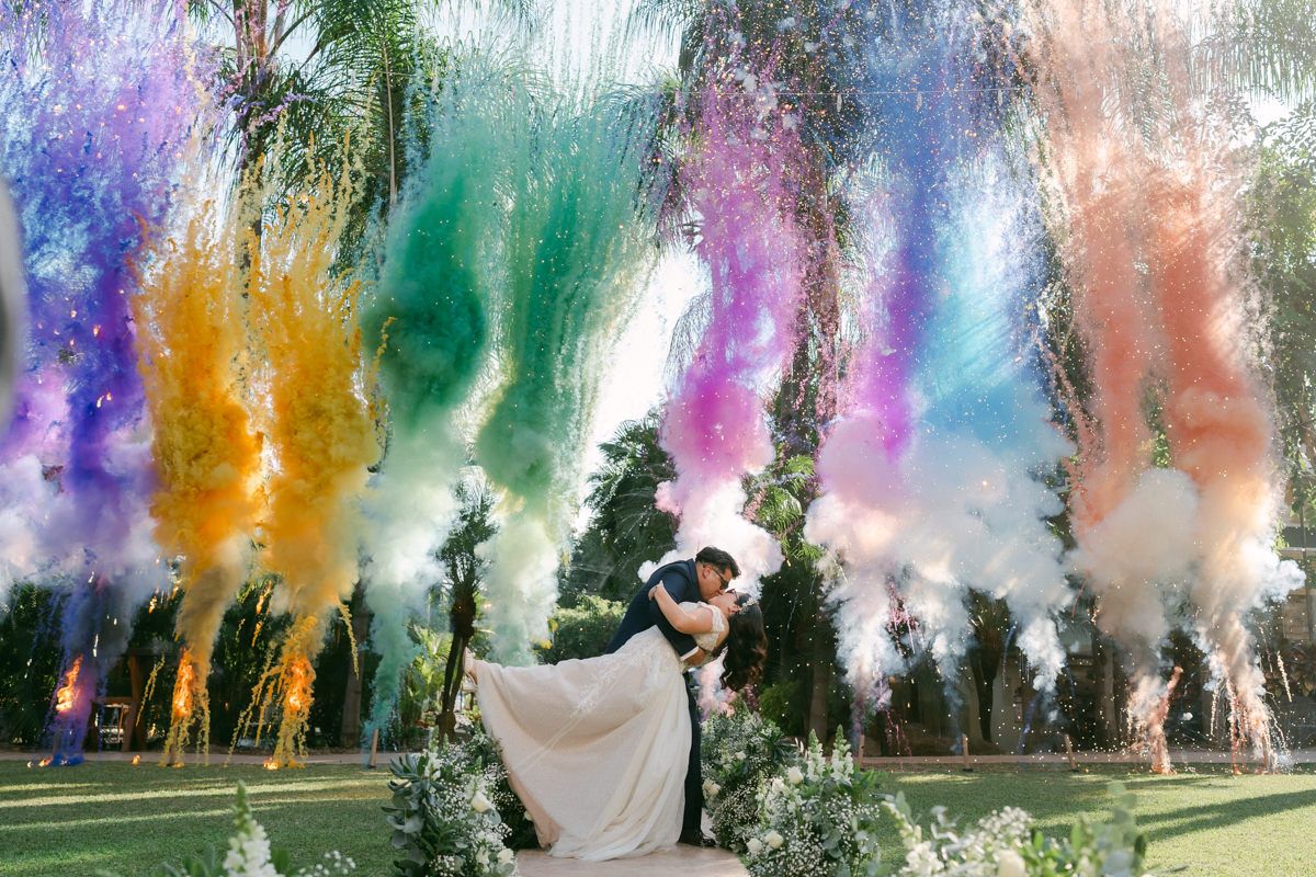 Entrada de novios con bombas de colores en Jardín Finca Paraíso; fotografía de boda auténtica y fiesta vibrante en Morelos por Luiz del Rio.