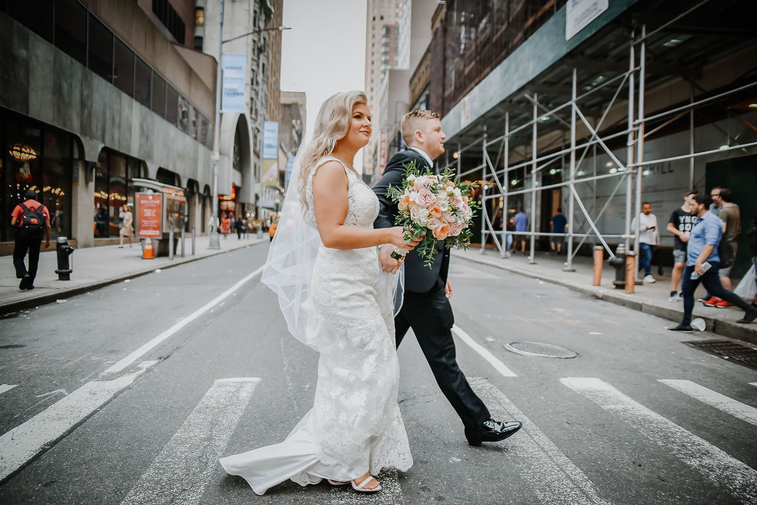 A happy couple shares a humorous moment while exiting a rustic wooden door during their wedding celebration.