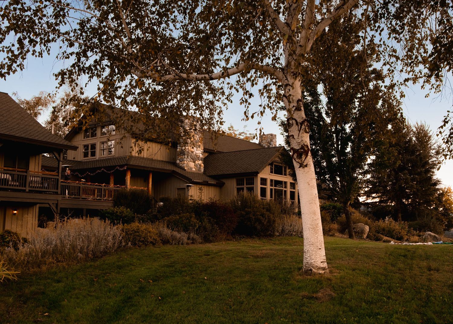 Panoramic view of houses on a hillside with autumn trees in warm evening light.