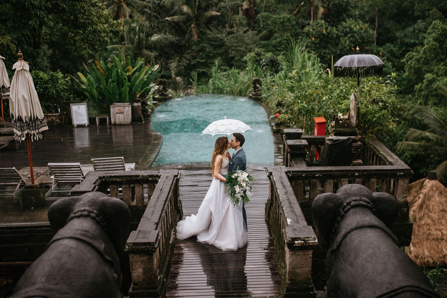 Wedding ceremony space decorated with elegant floral arches and white roses in natural setting.